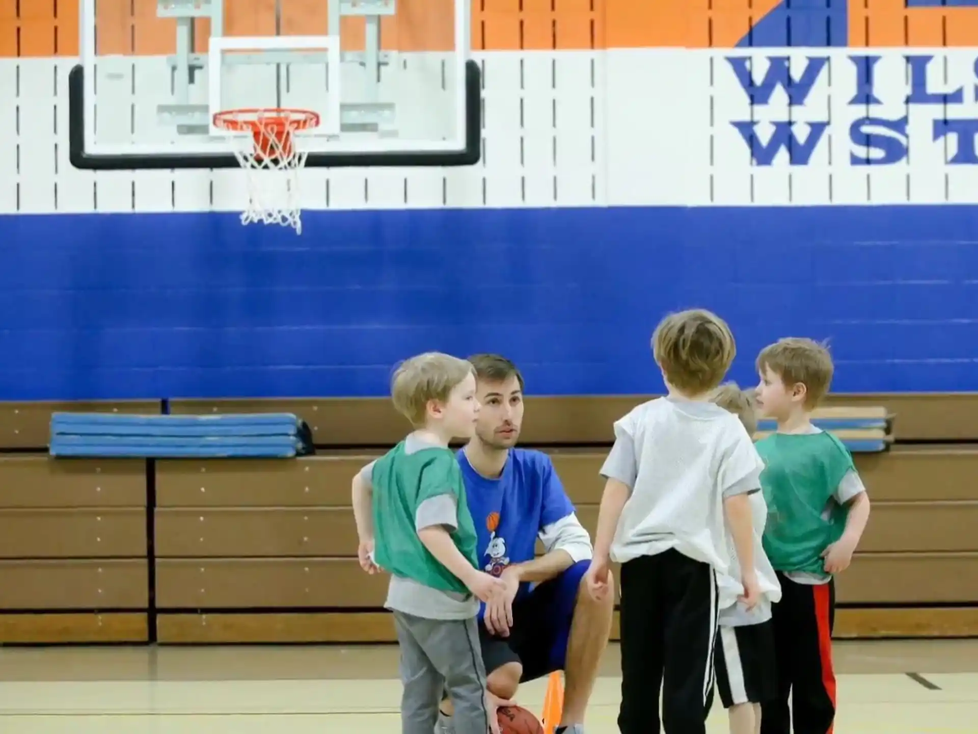 a group of boys standing in front of a basketball court