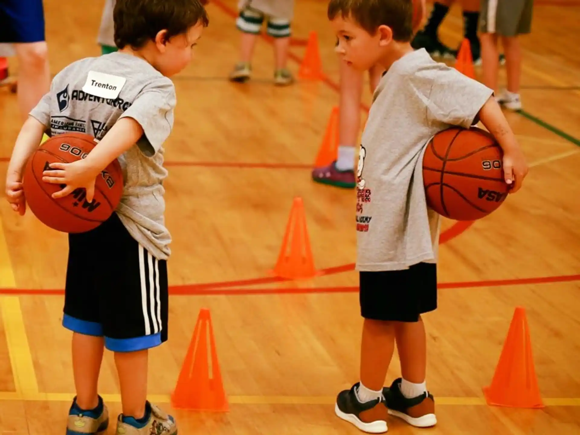 a couple of boys holding basketballs