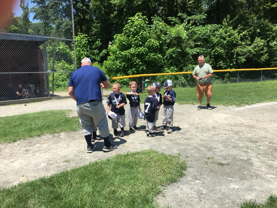 a group of kids standing on a baseball field