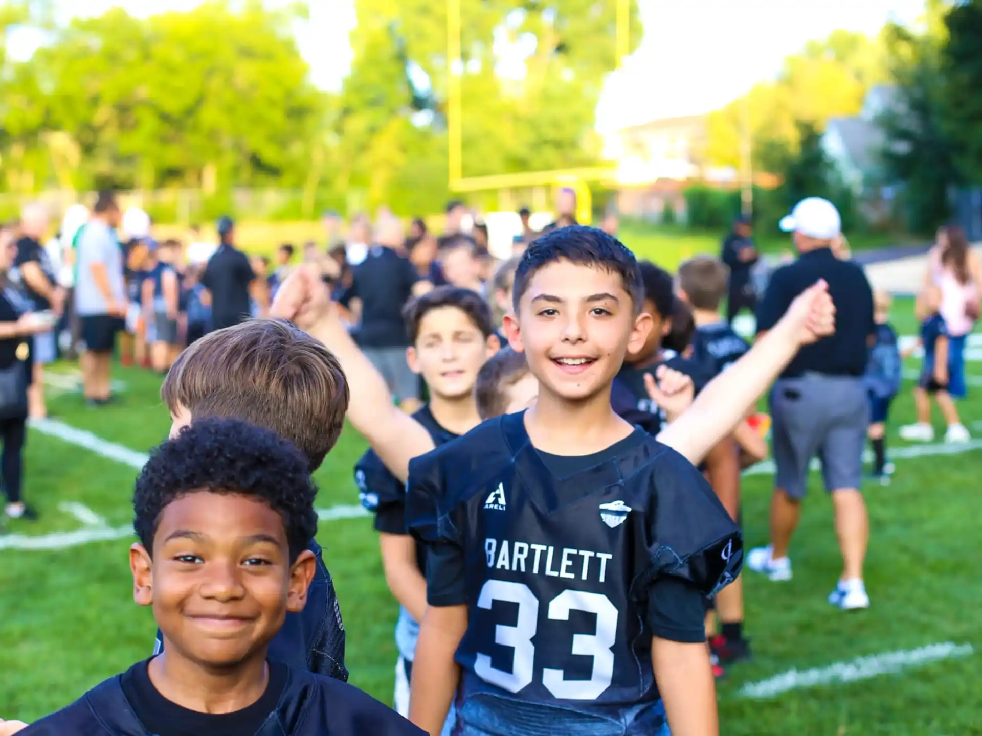 a group of boys posing for a picture on a football field