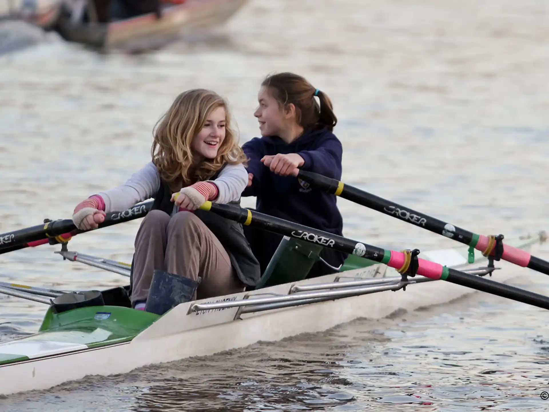 a group of girls rowing a boat