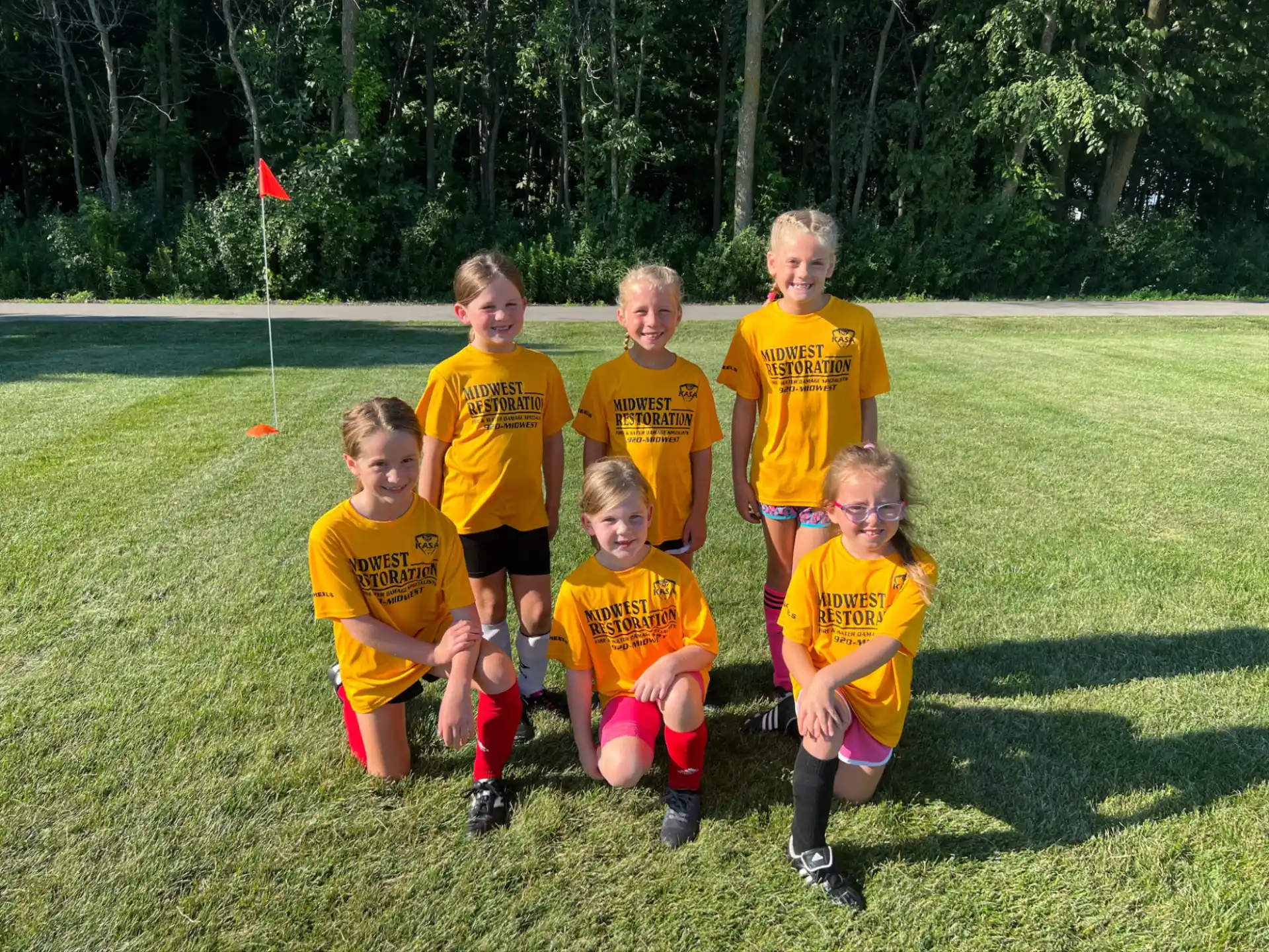 a group of kids in yellow uniforms