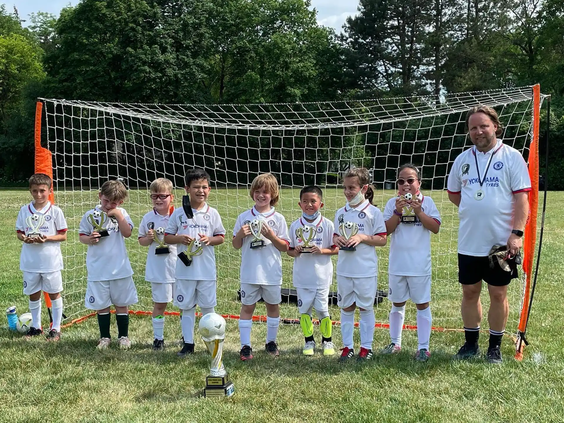 a group of kids posing for a picture with a trophy