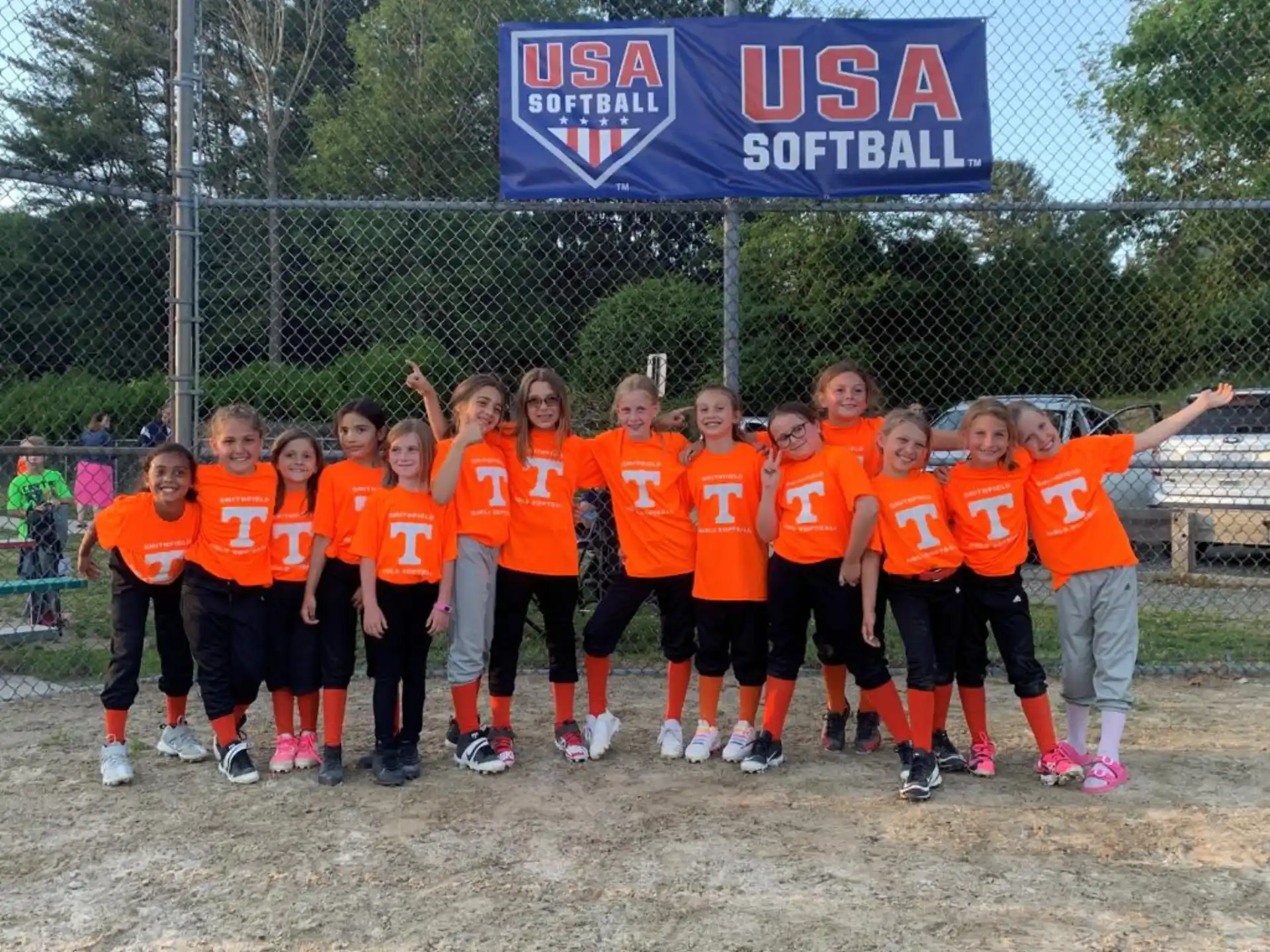 a group of kids in orange shirts