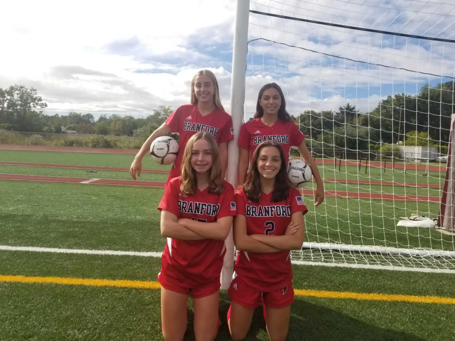 a group of girls posing for a picture on a field