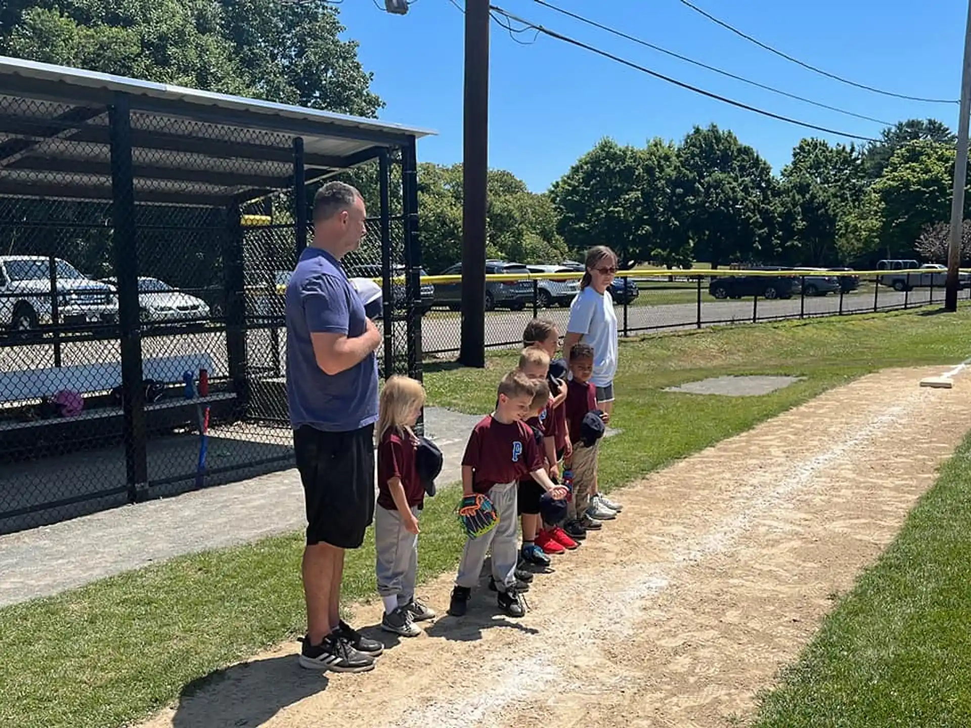 a group of kids standing on a baseball field