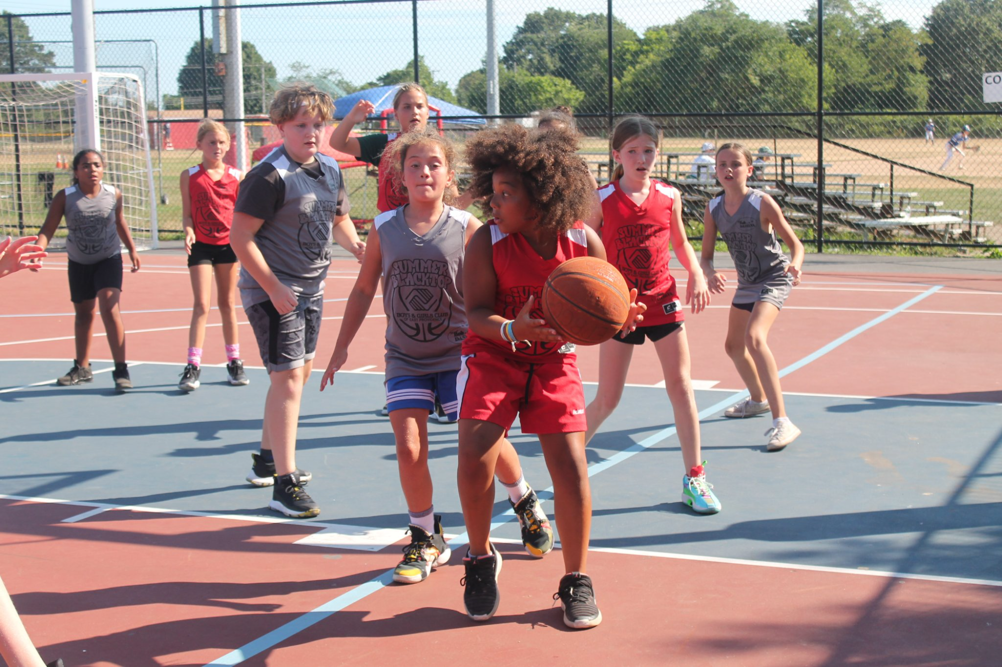 a group of kids playing basketball