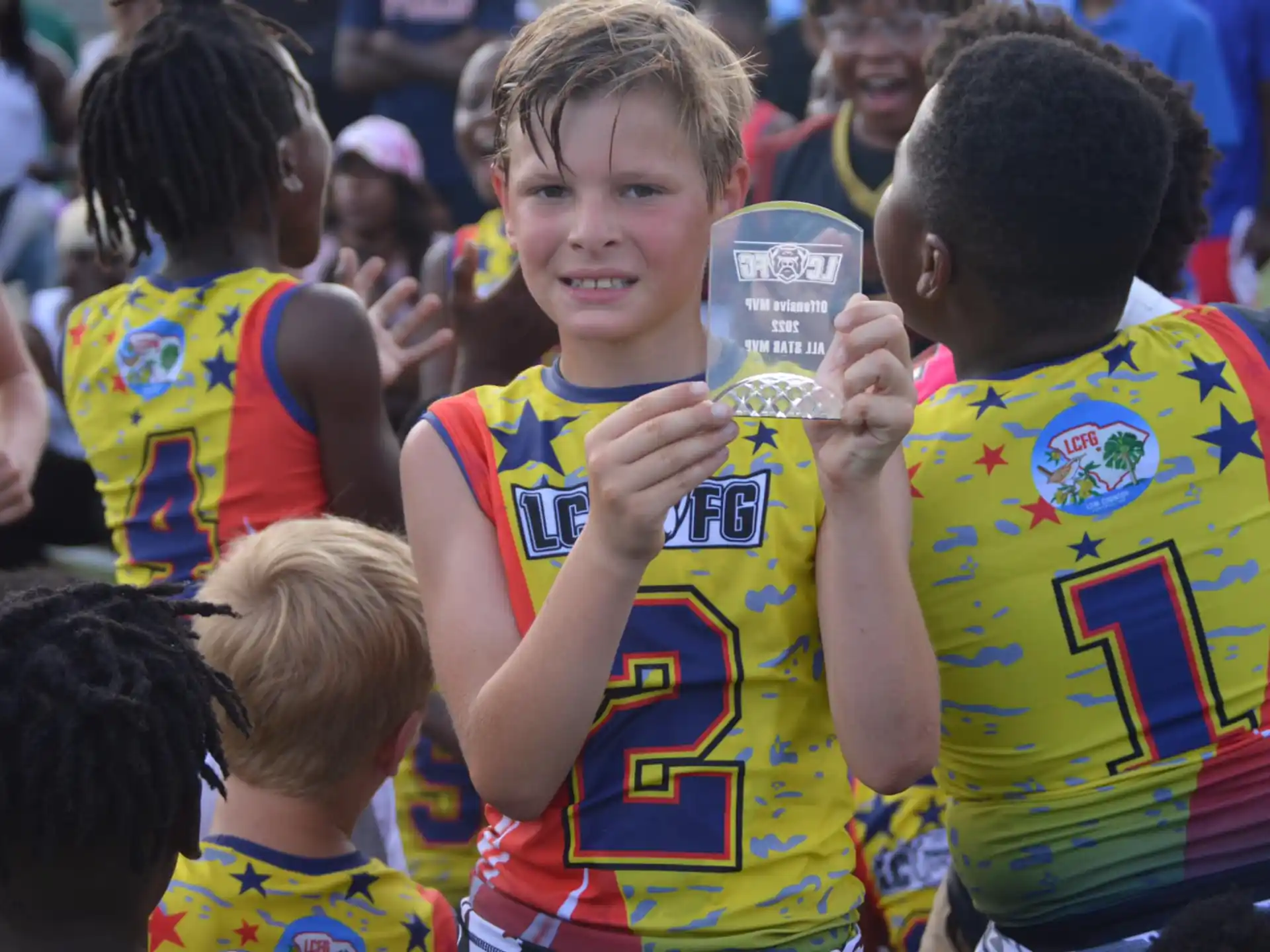 a boy holding a trophy