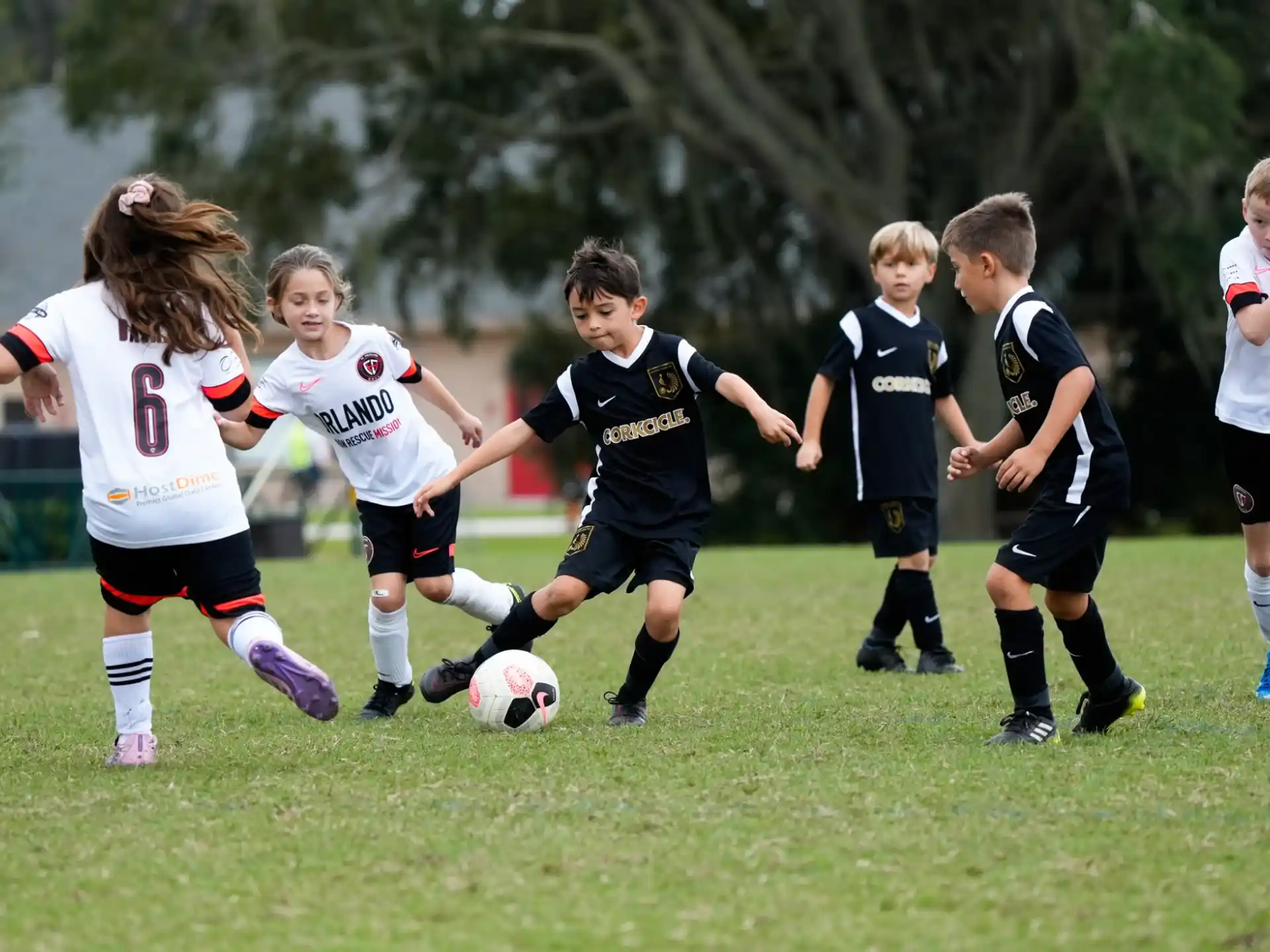a group of kids compete over a football ball