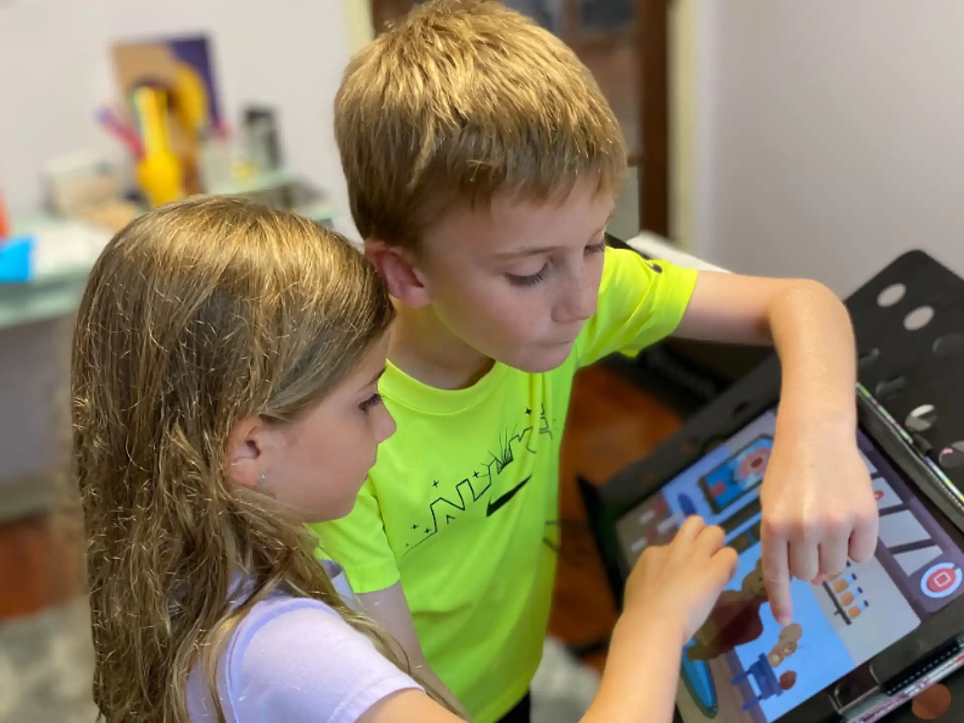 a boy and girl looking at a laptop