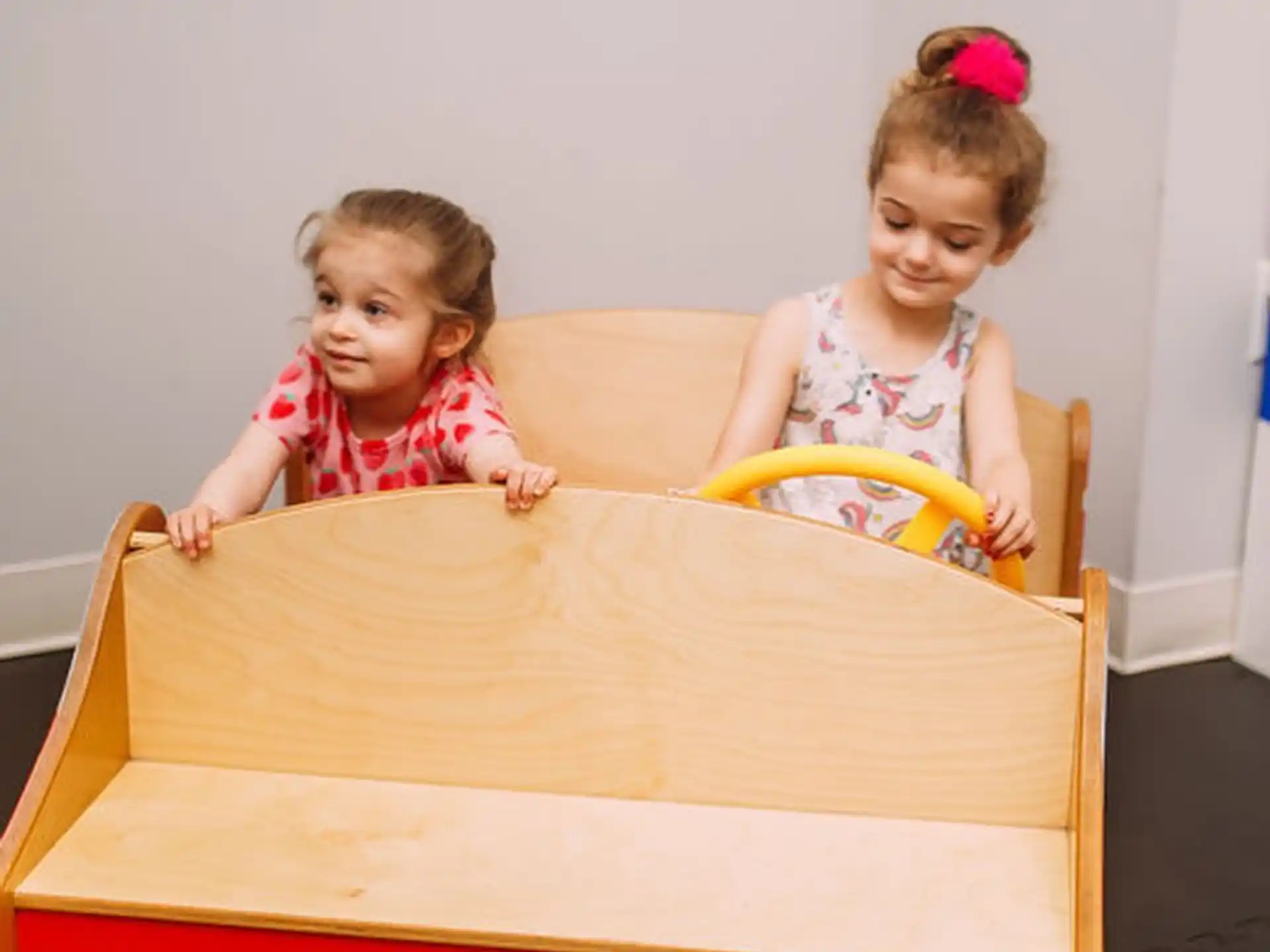 a couple of girls sitting on a couch with a box