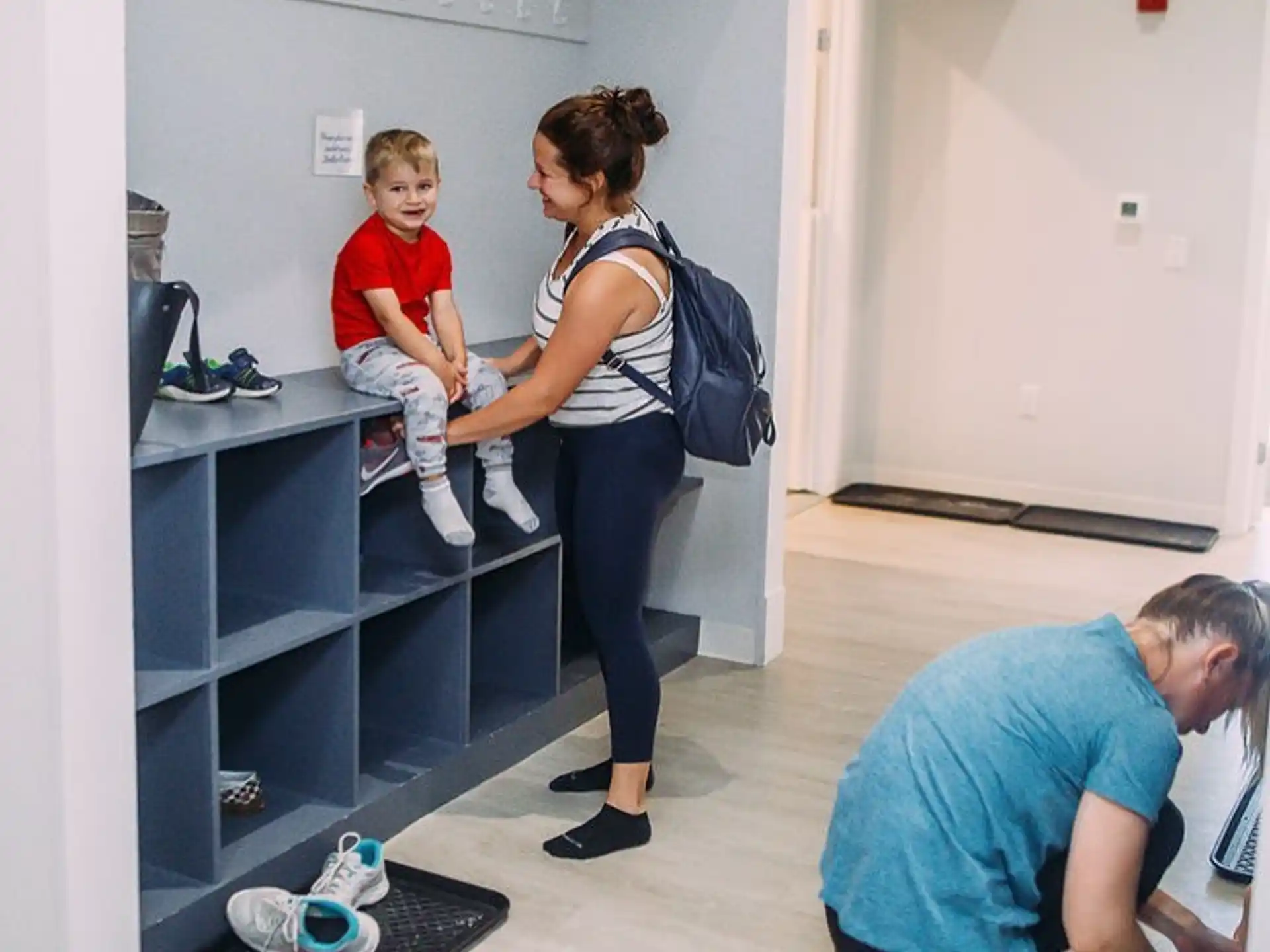 a person standing in a room with a group of people sitting on a shelf