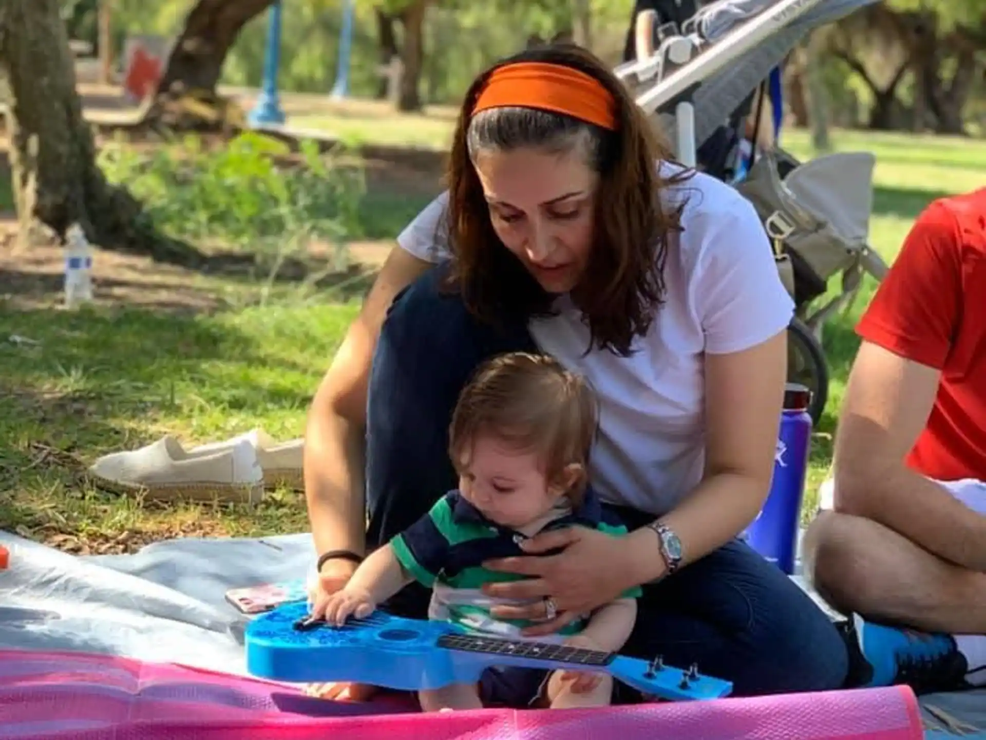 a person and a child sitting on a blanket outside