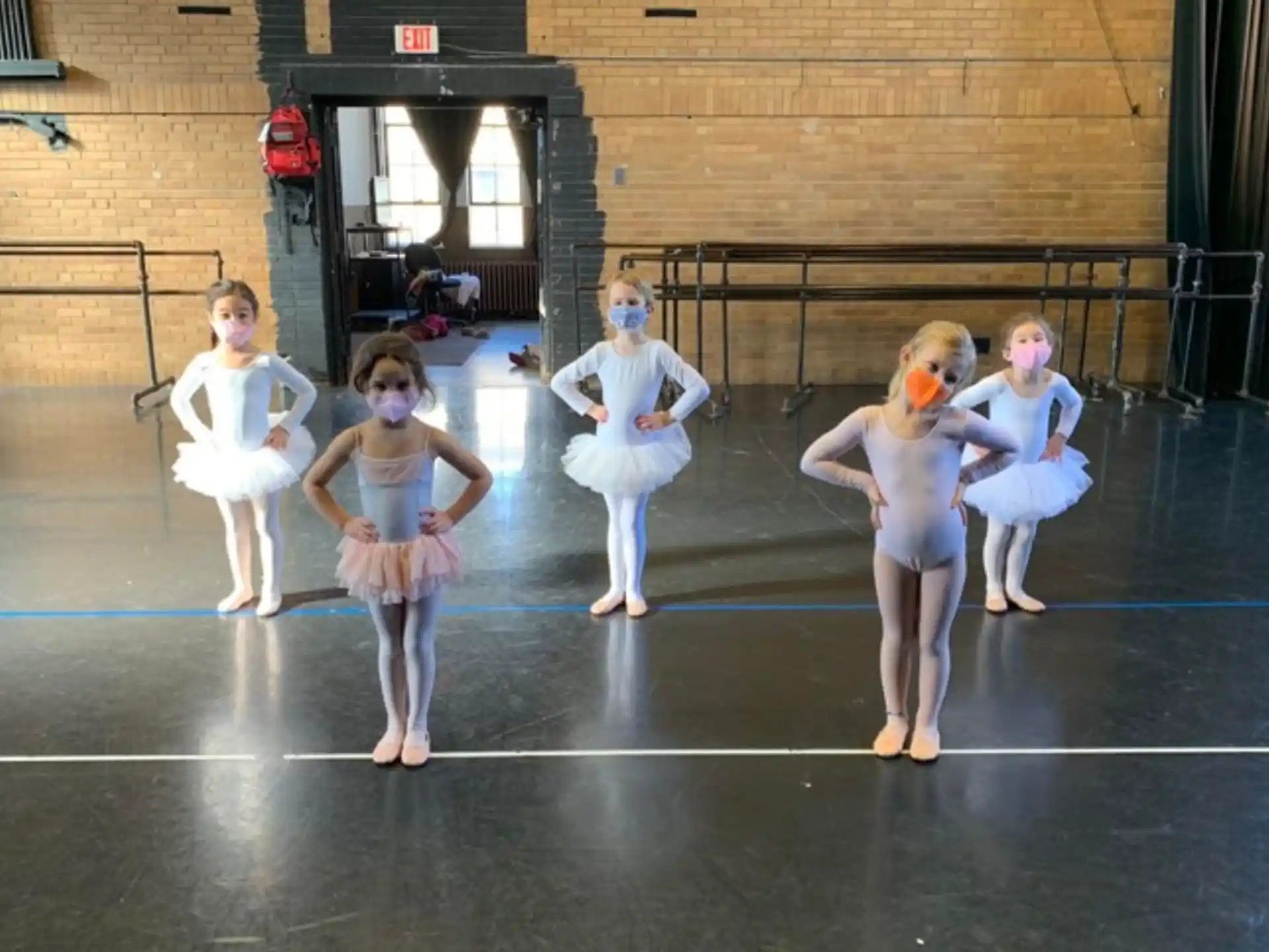 a group of girls in white outfits dancing on a court