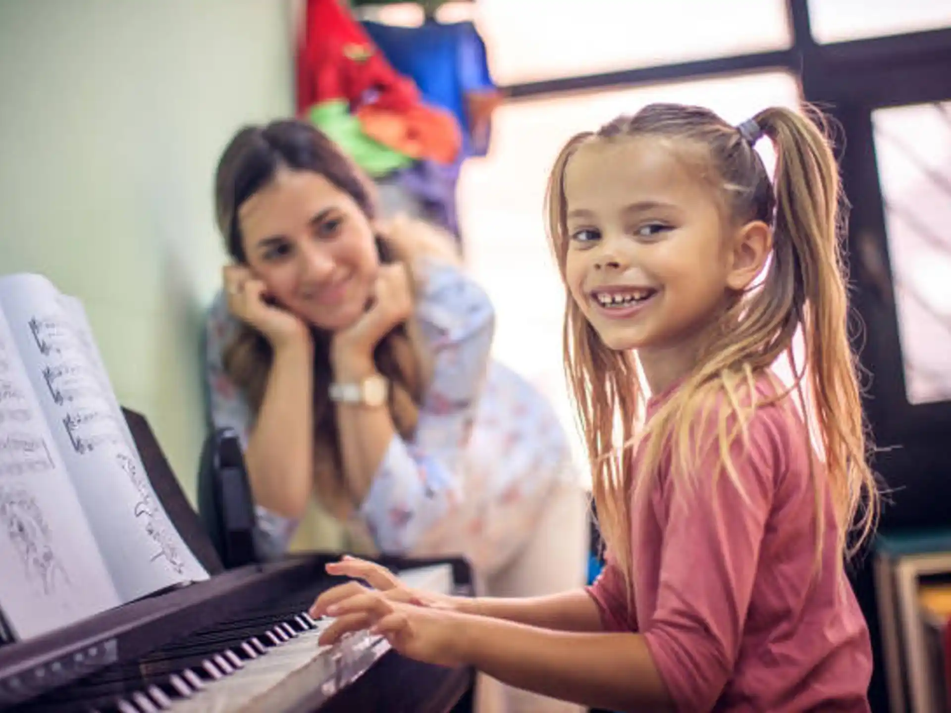 a few young girls playing piano