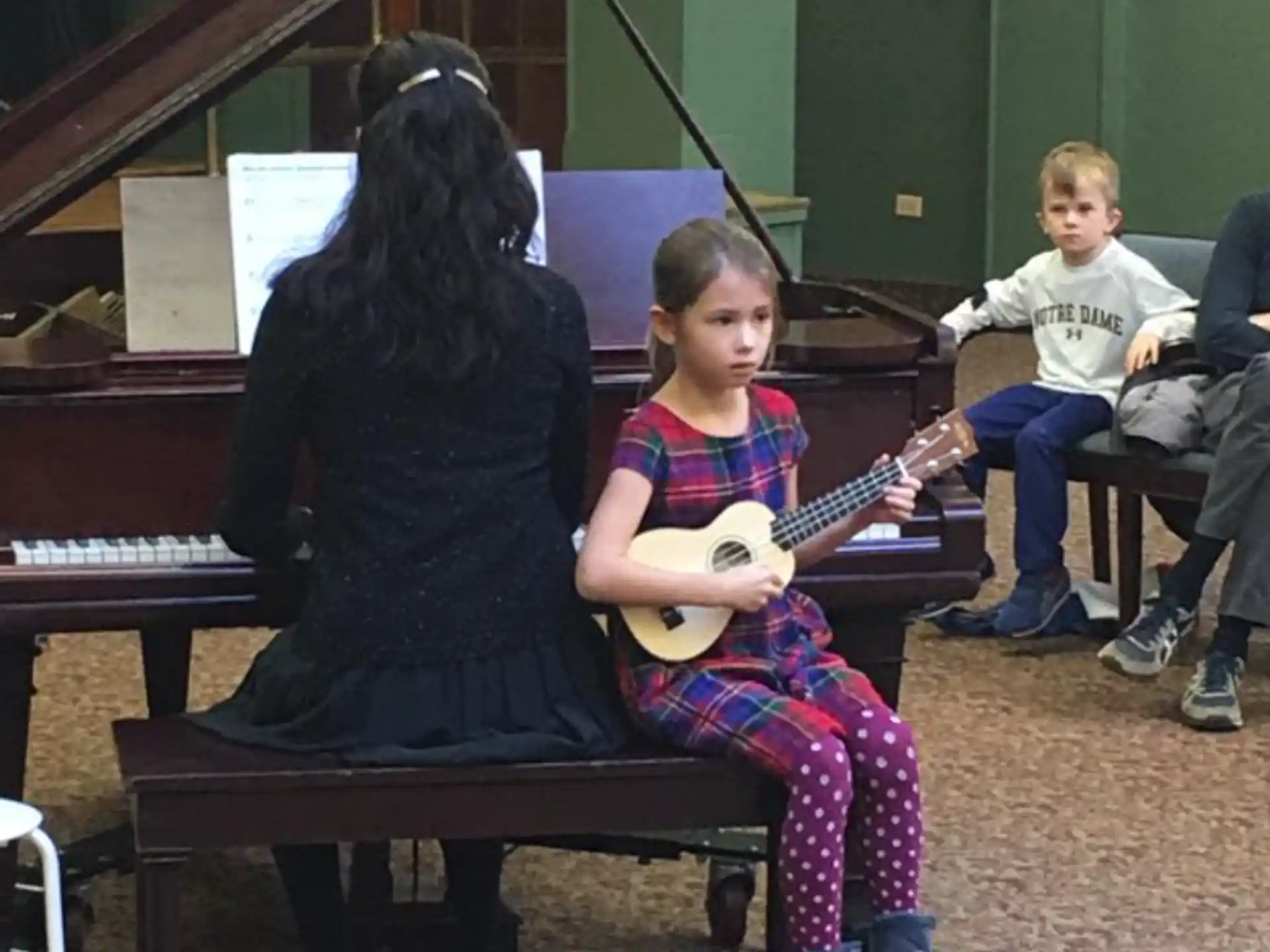 a person playing a guitar to a young girl