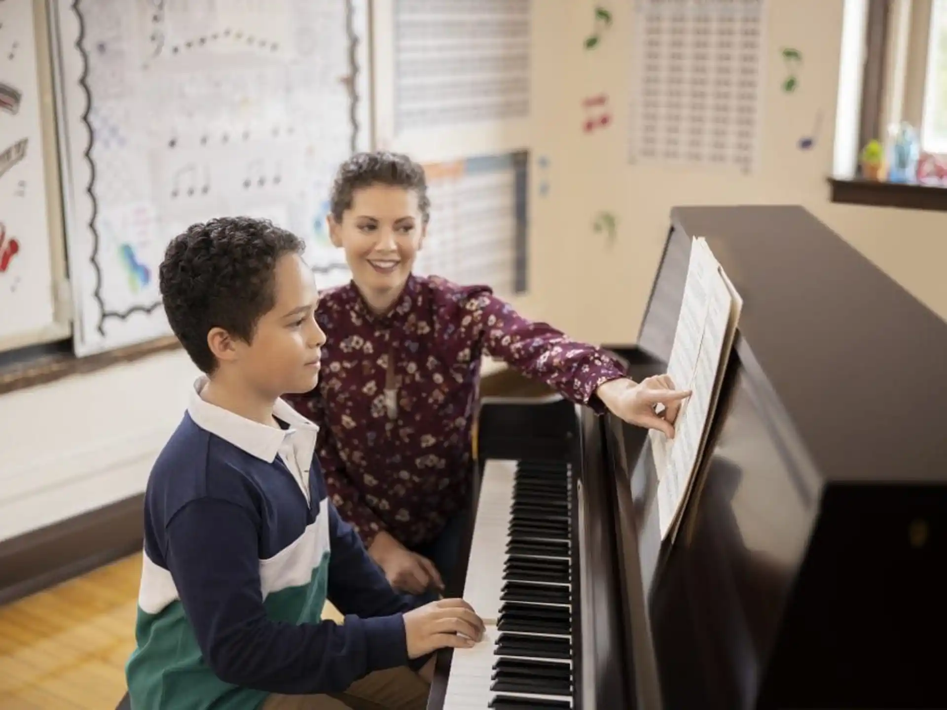 a person and a boy playing piano