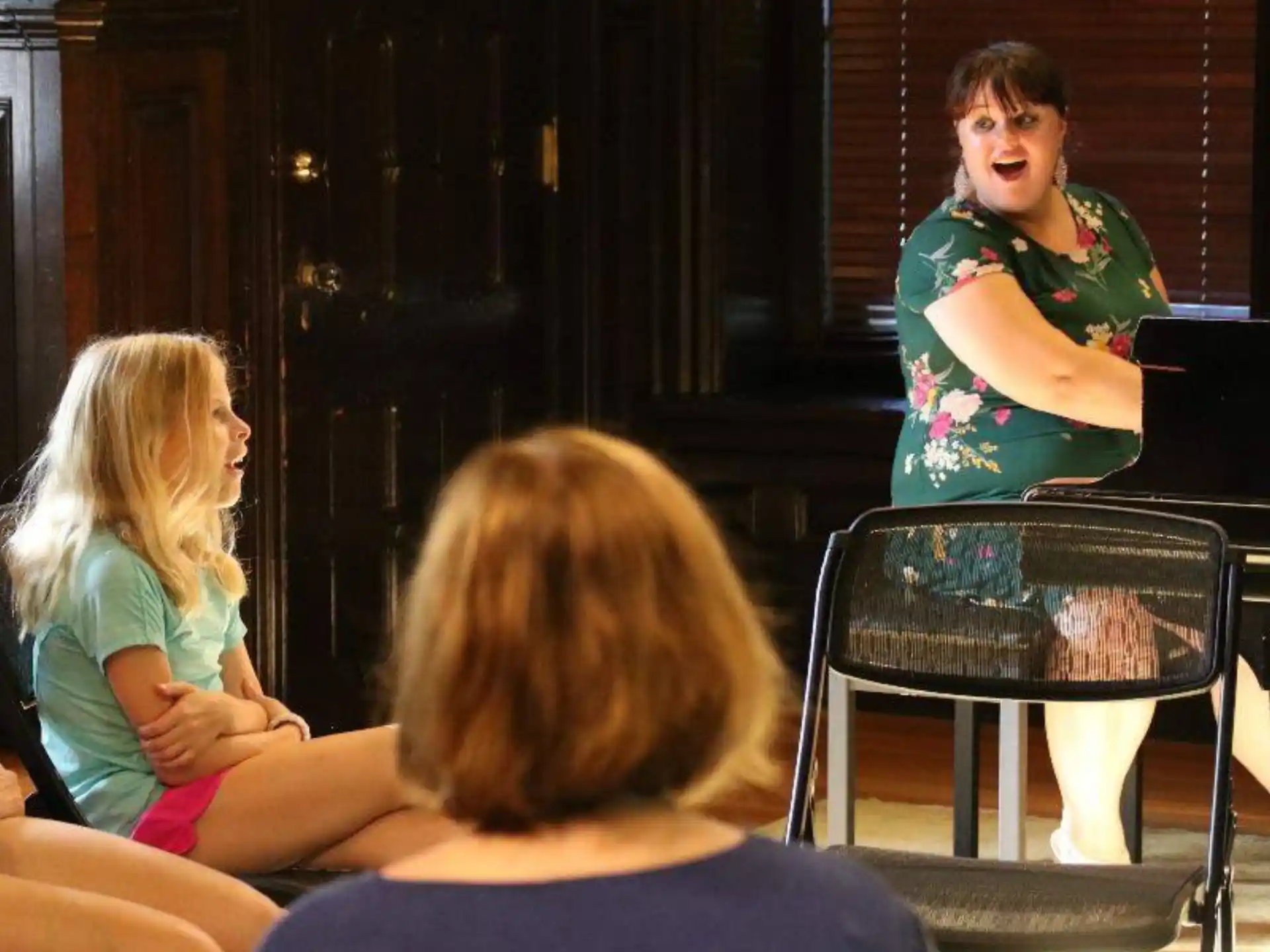 a woman singing to a group of children