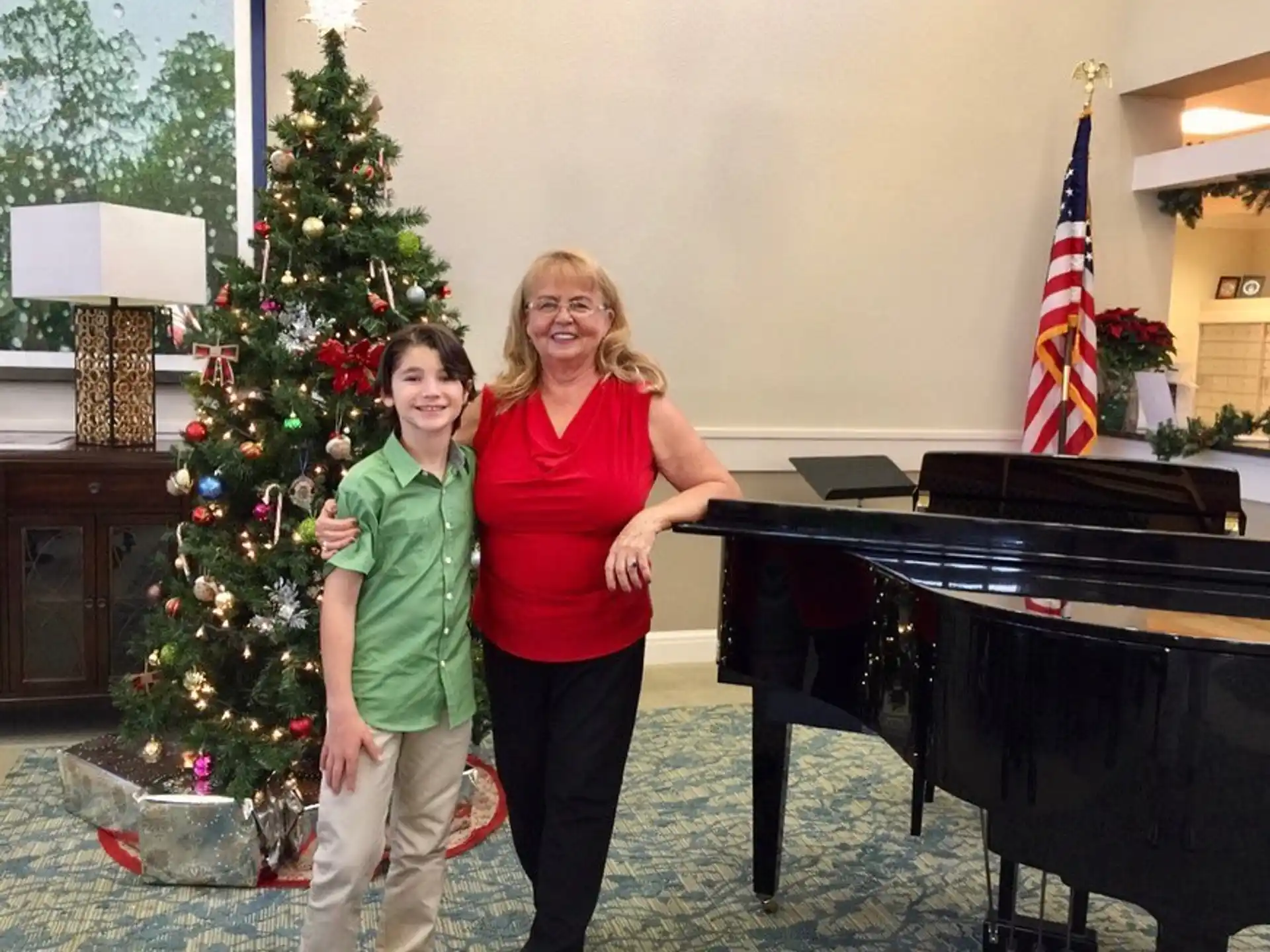 a couple of women posing for a picture next to a christmas tree