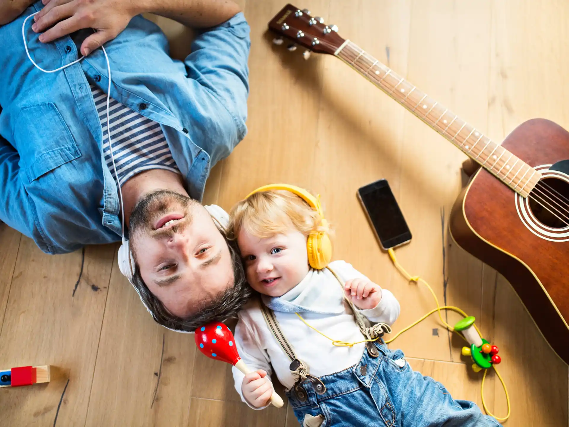 a person and a child playing with a guitar