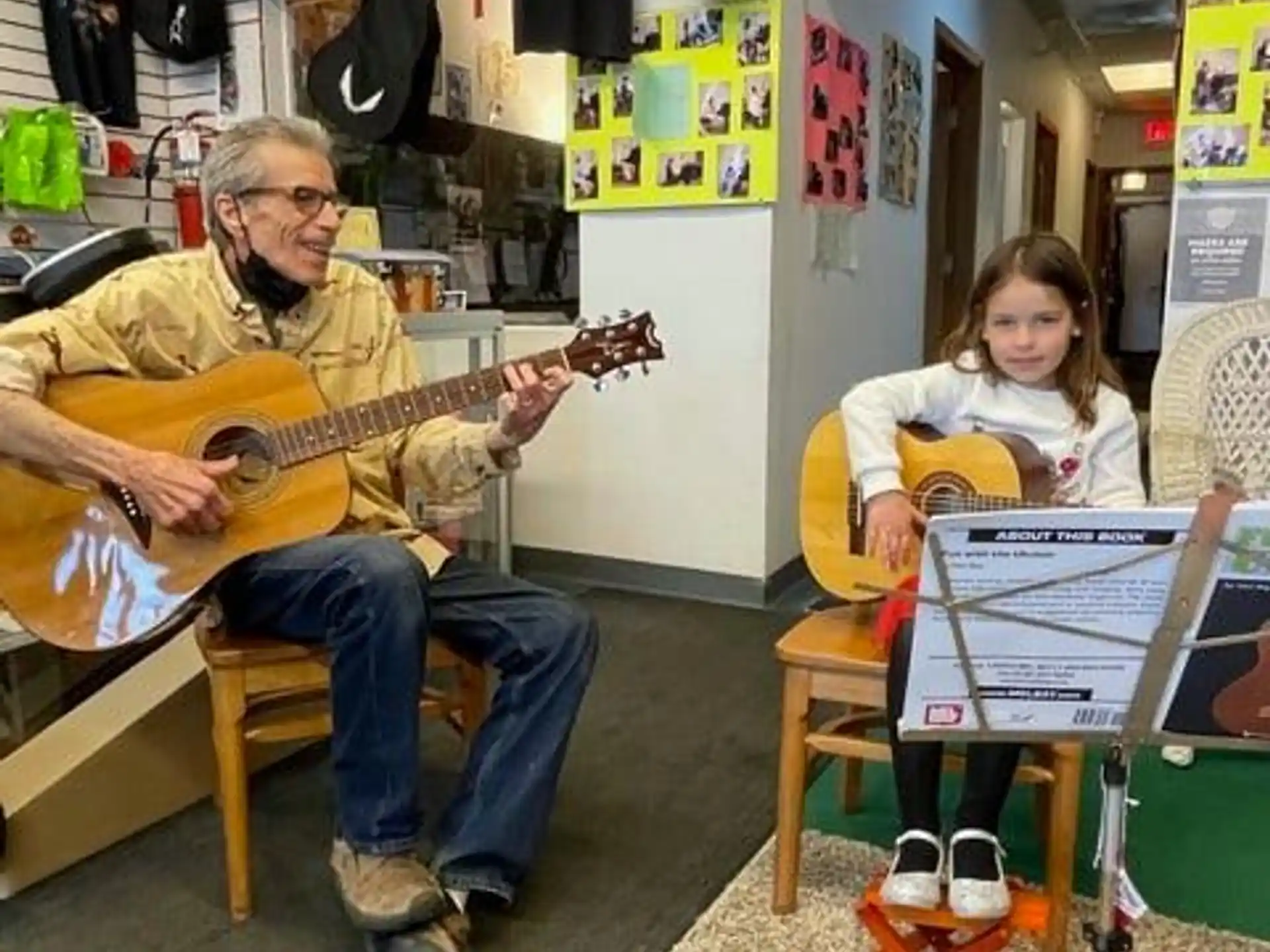 a person and a girl playing guitars
