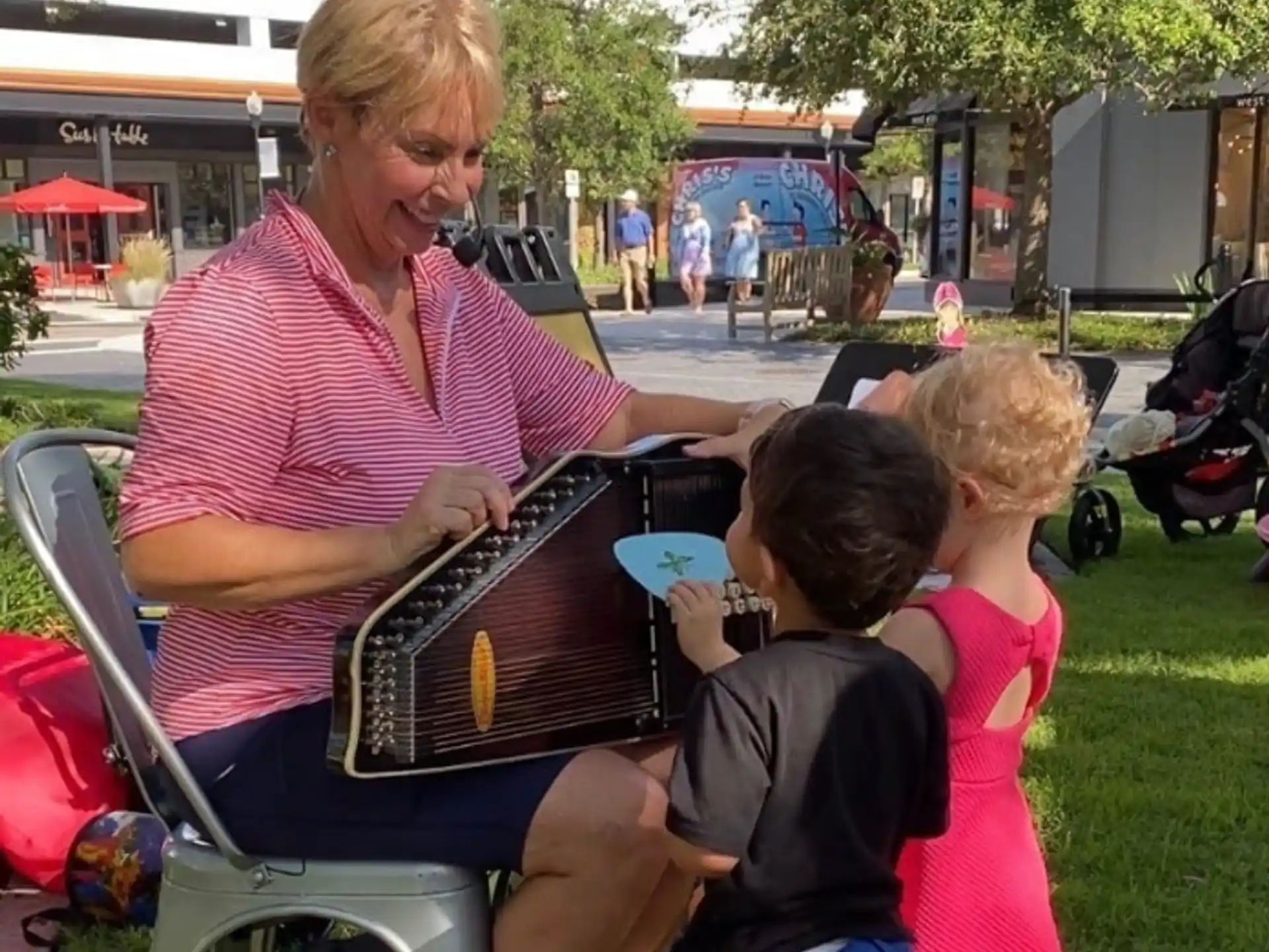 a person playing an accordion with a couple of kids