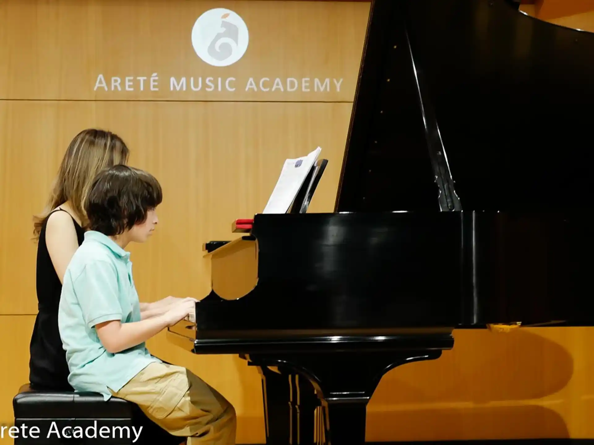 a boy and girl playing piano