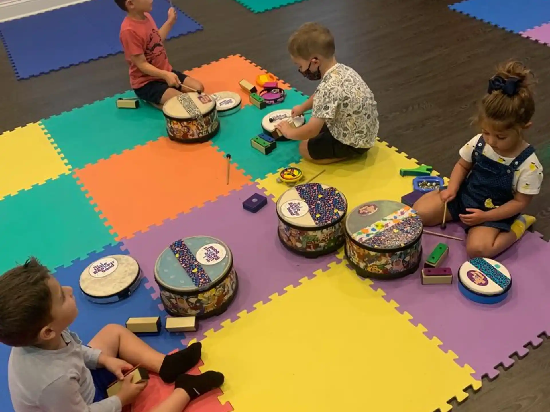 a group of children playing on a colorful mat