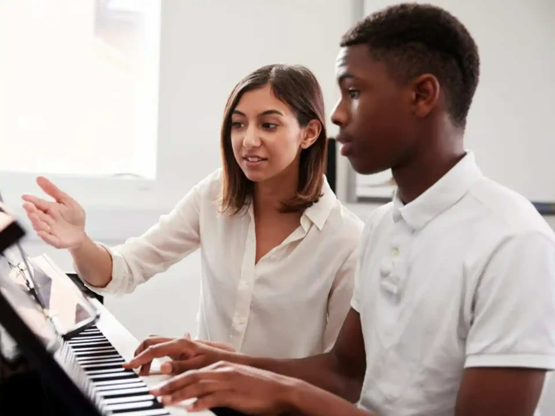 a man and a woman playing a piano