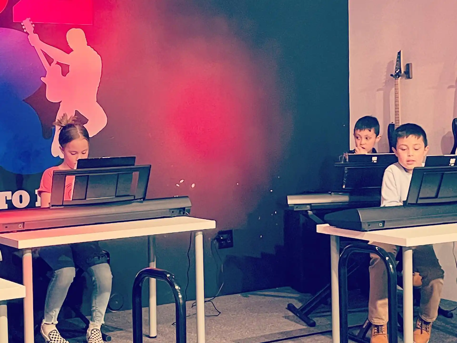 a group of people sitting at desks with laptops