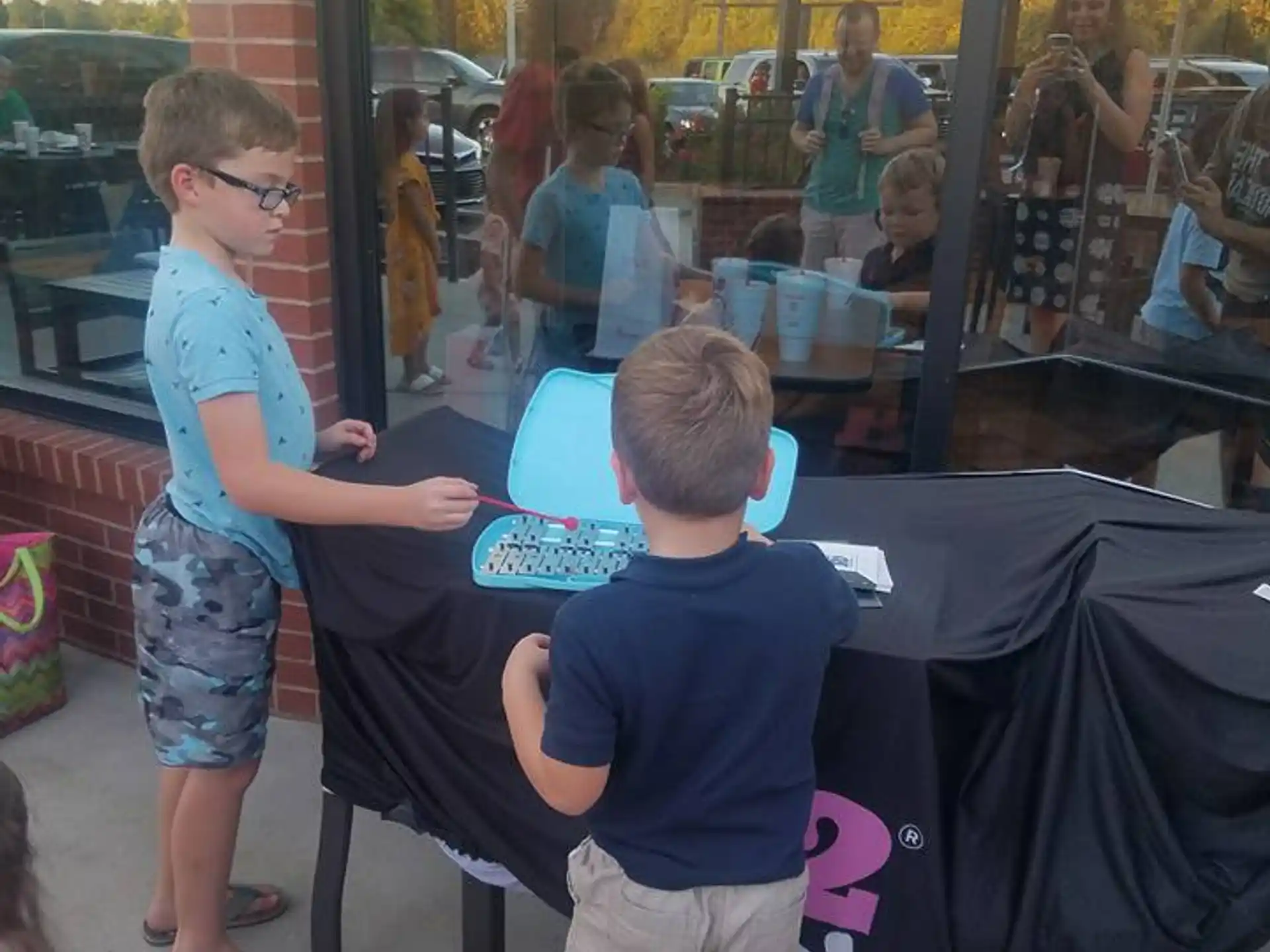 a person and a boy standing outside a store window