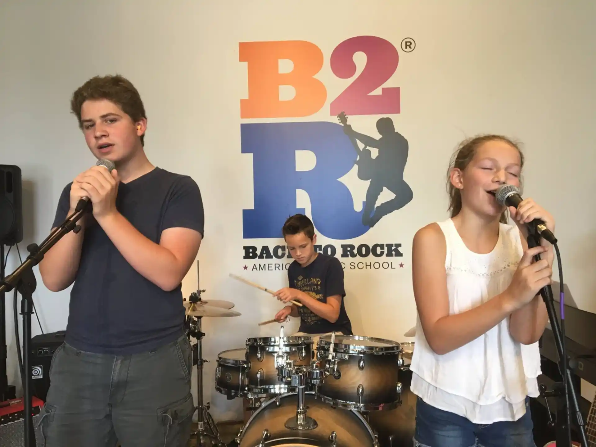 a group of people singing into microphones