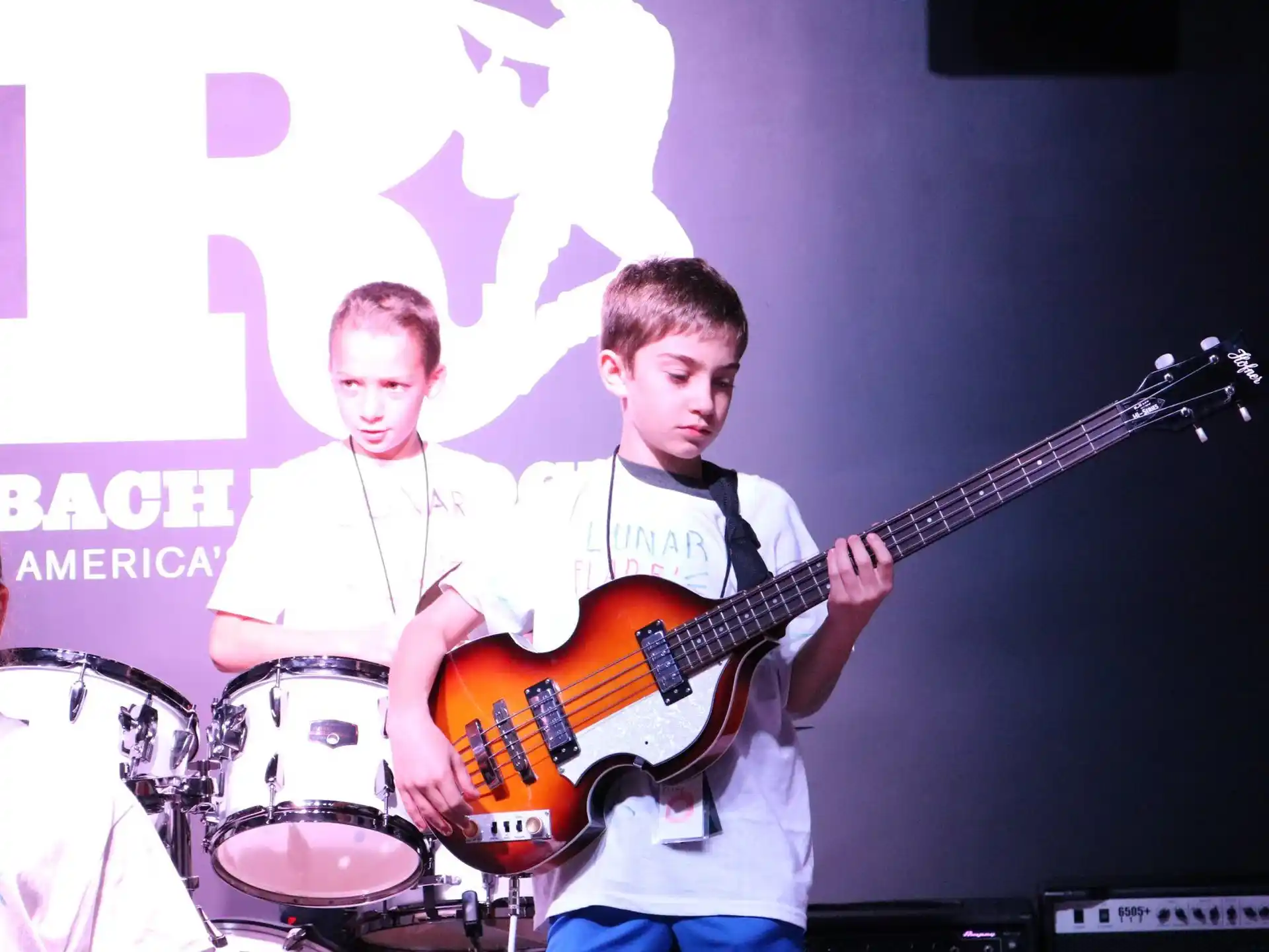 a man playing a guitar next to a man playing drums