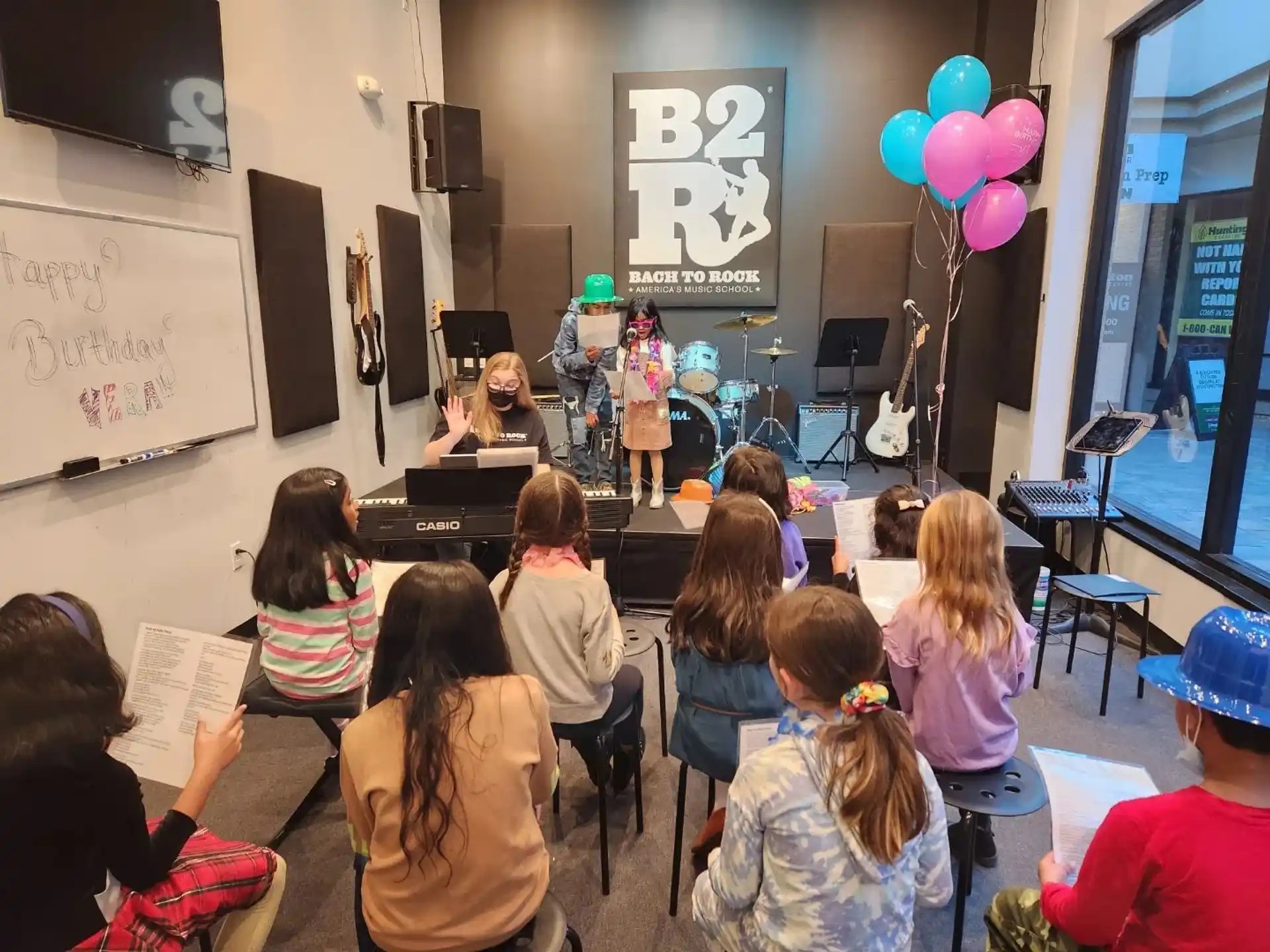 a group of people sitting in a room with a person playing a musical instrument
