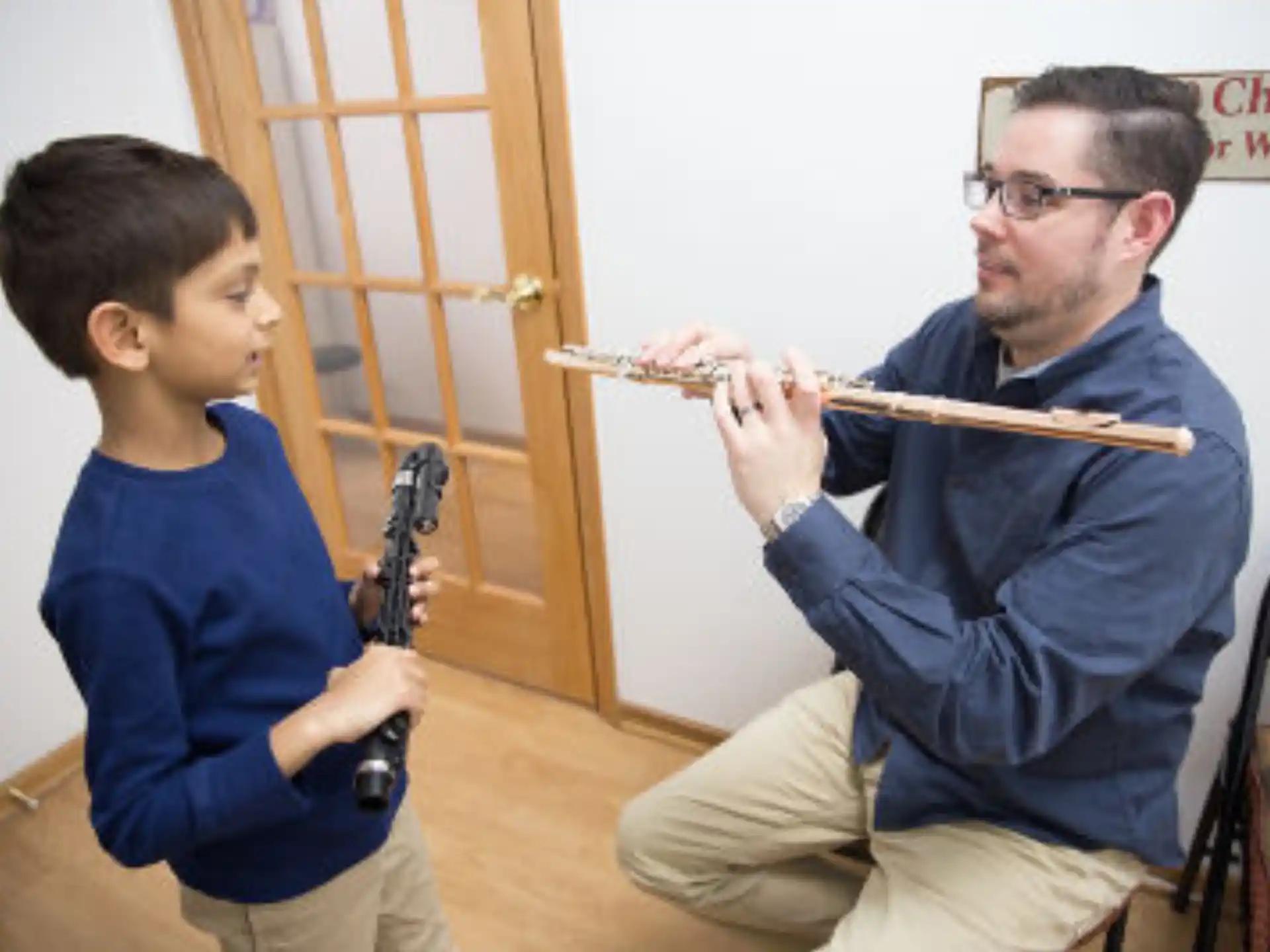 a person and a boy playing a flute