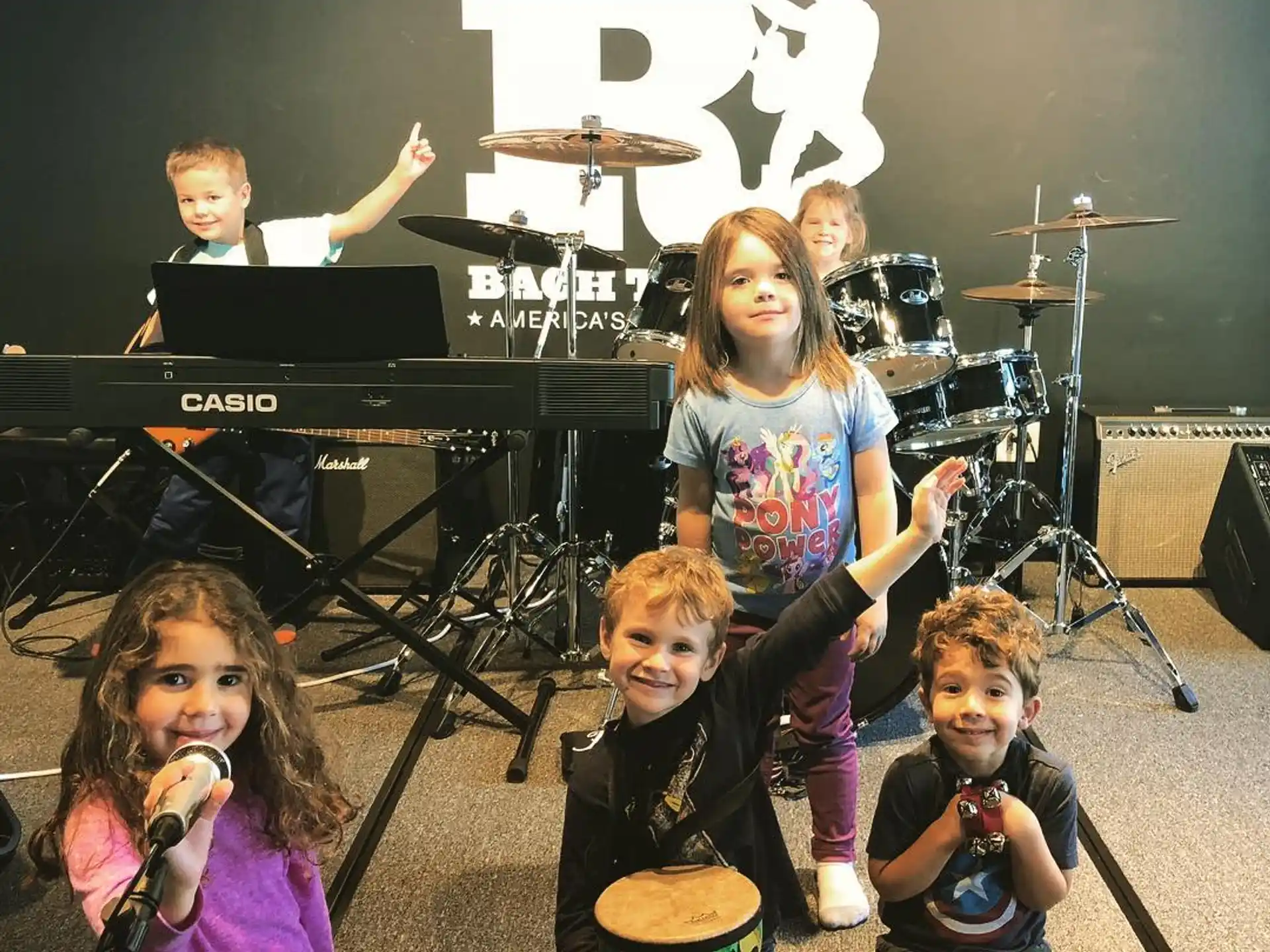 a group of kids singing on stage