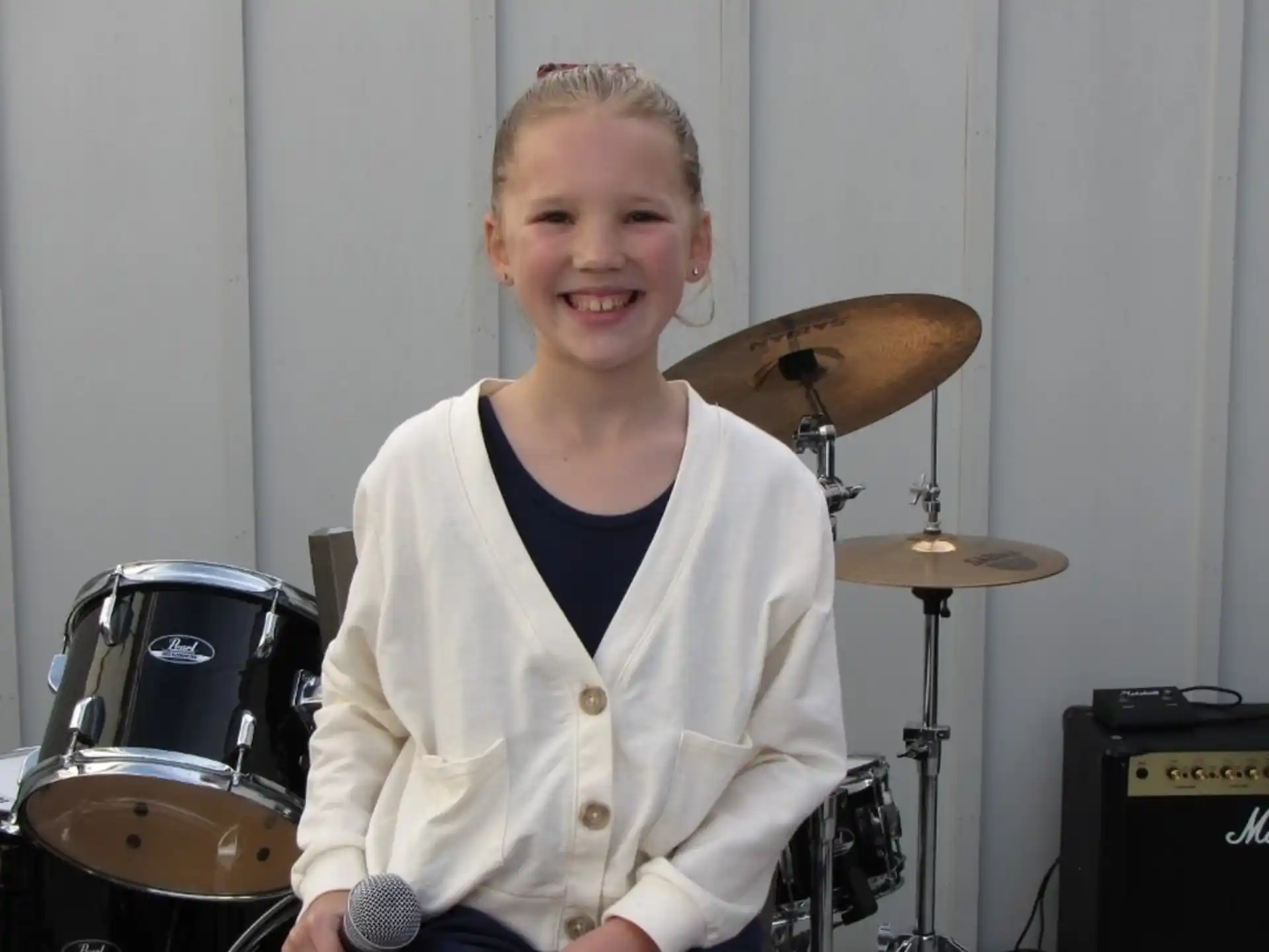 a person sitting in front of a drum set