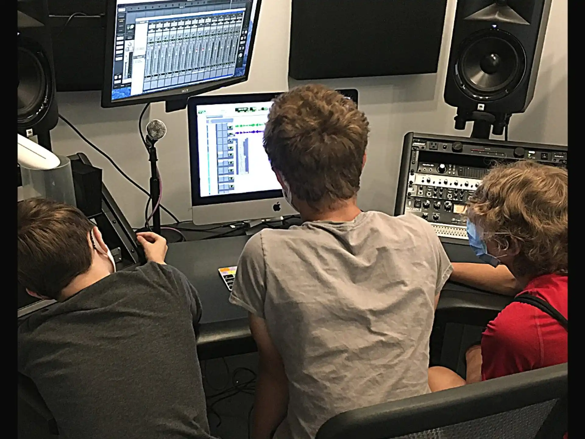 a group of people sitting in front of a computer