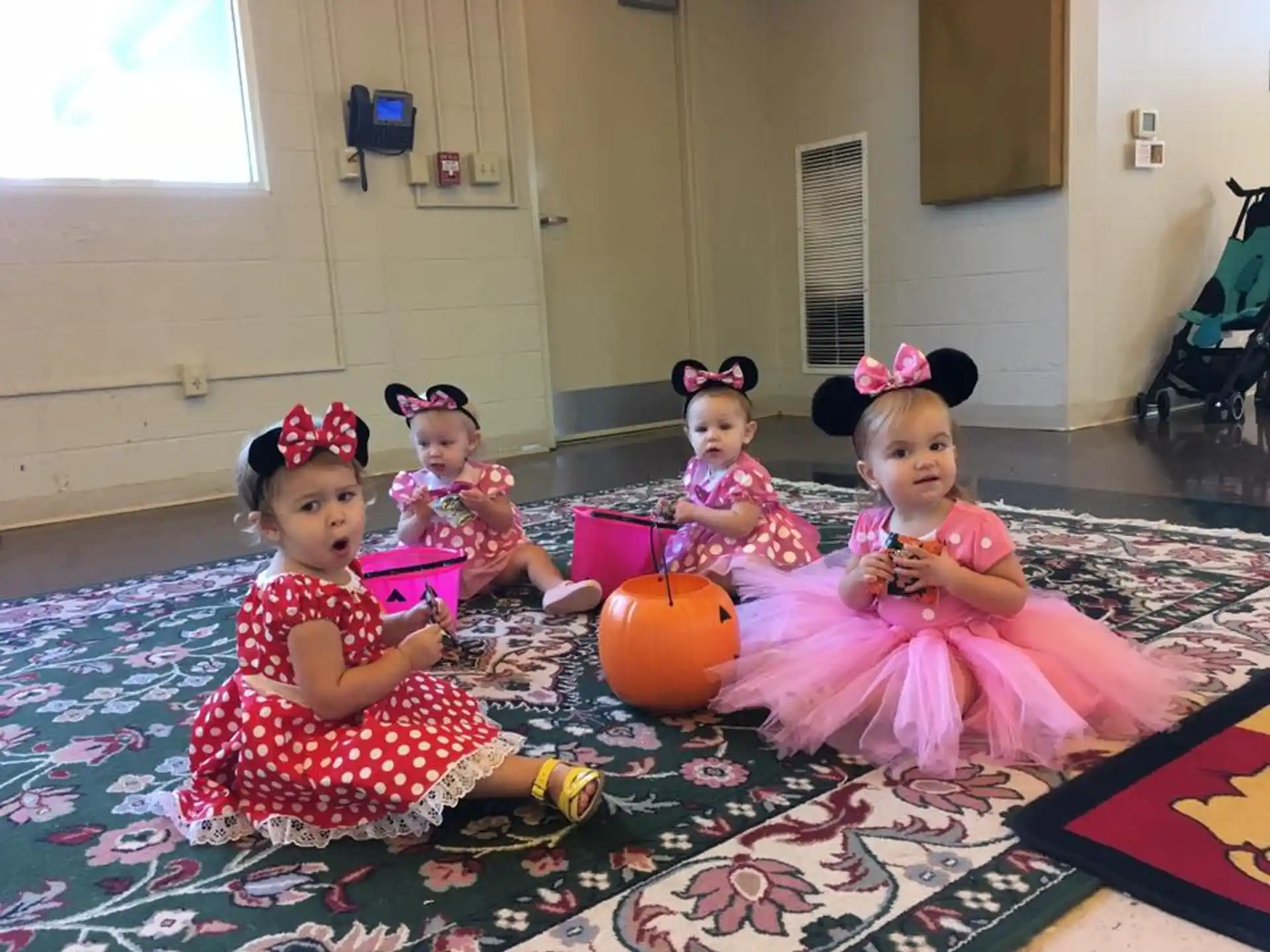 a group of girls sitting on the floor with a pumpkin and a pumpkin