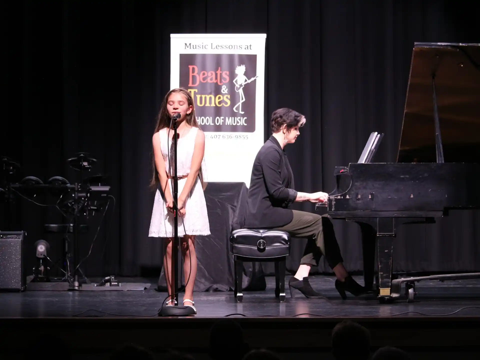 a man and a woman on a stage with musical instruments