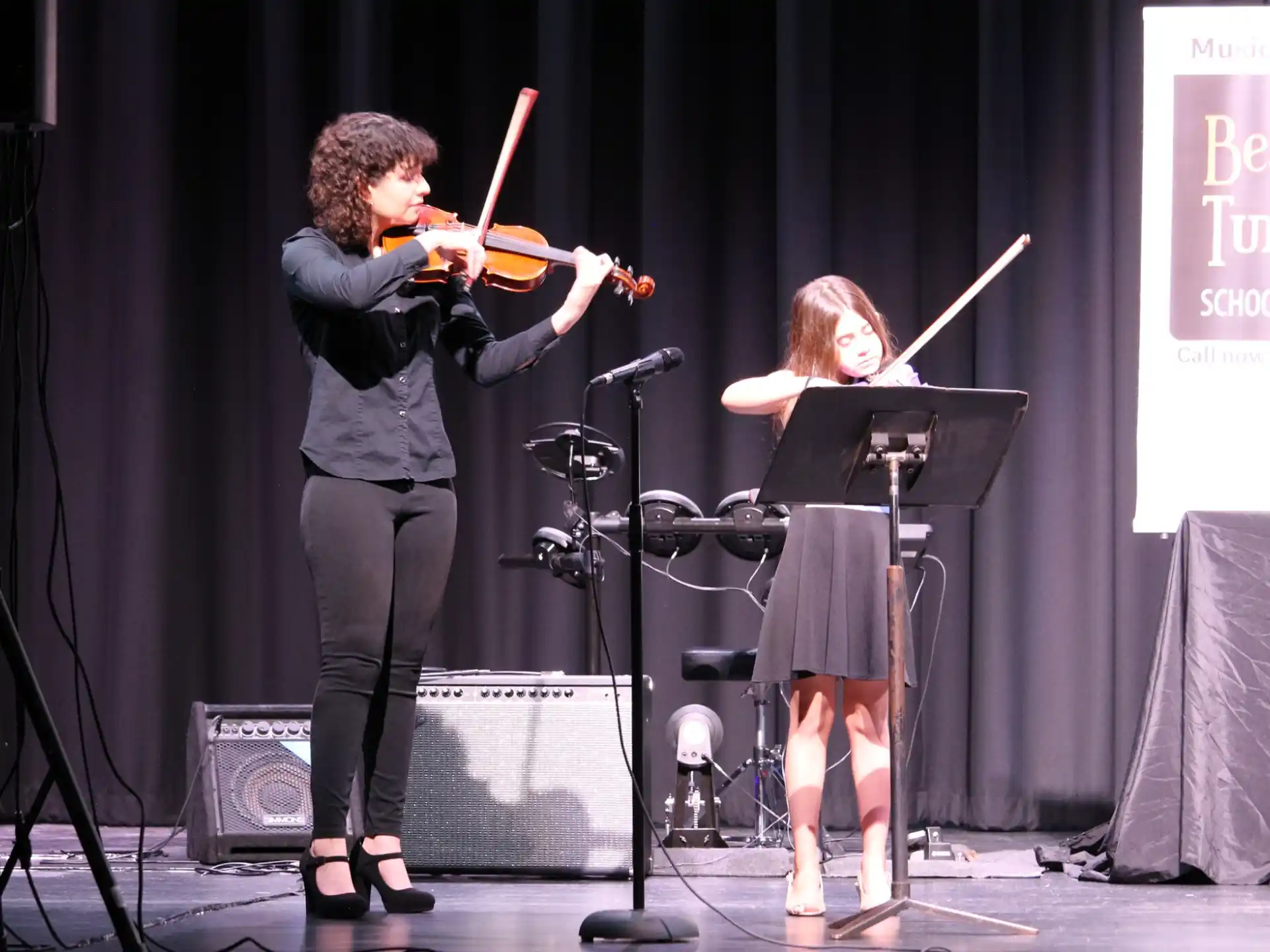a man and a woman playing the violin on a stage