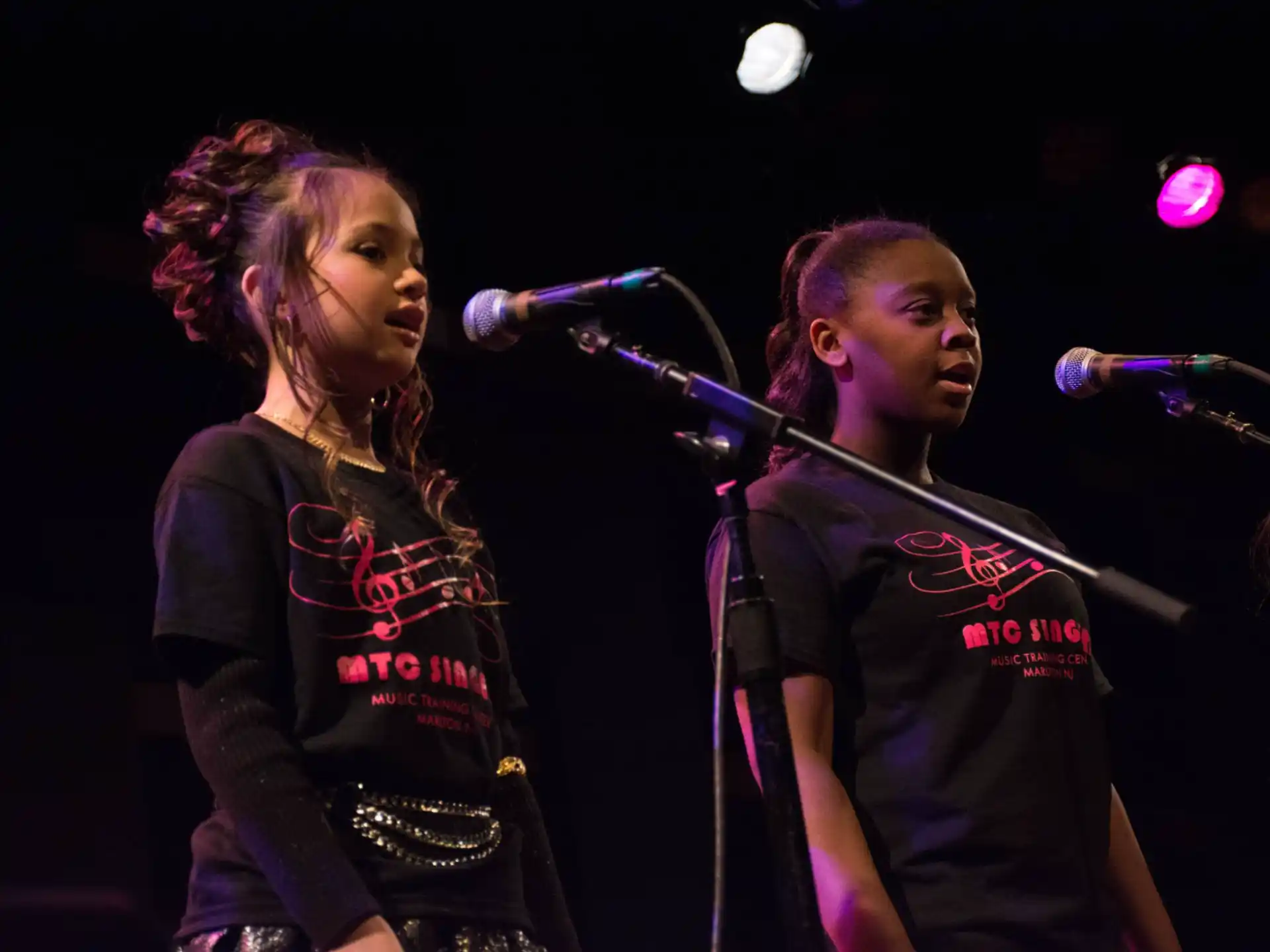 a man and woman singing on stage