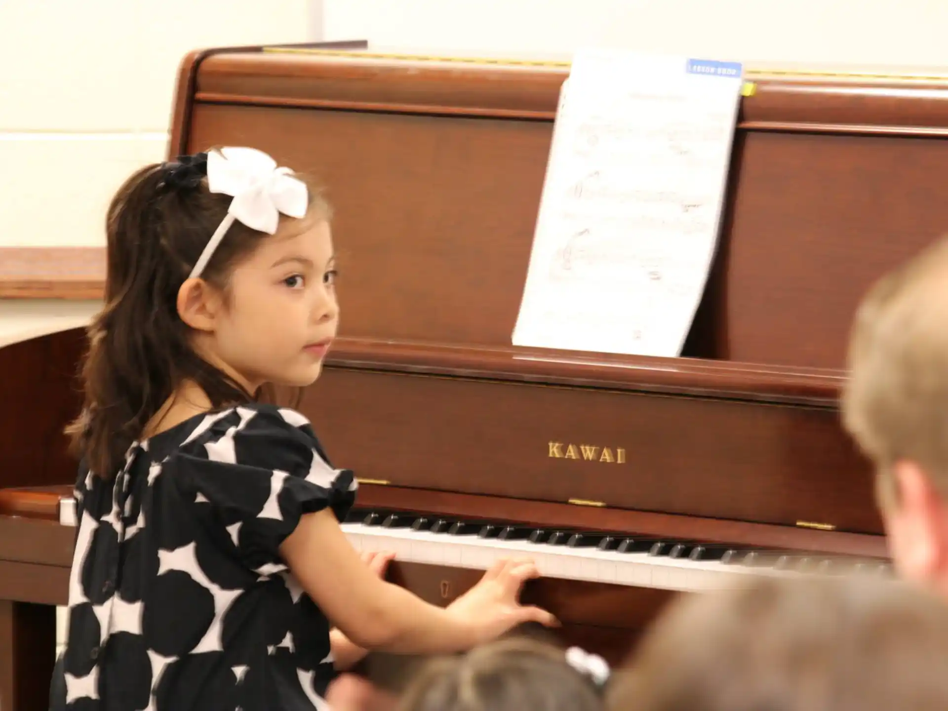 a young girl playing a piano