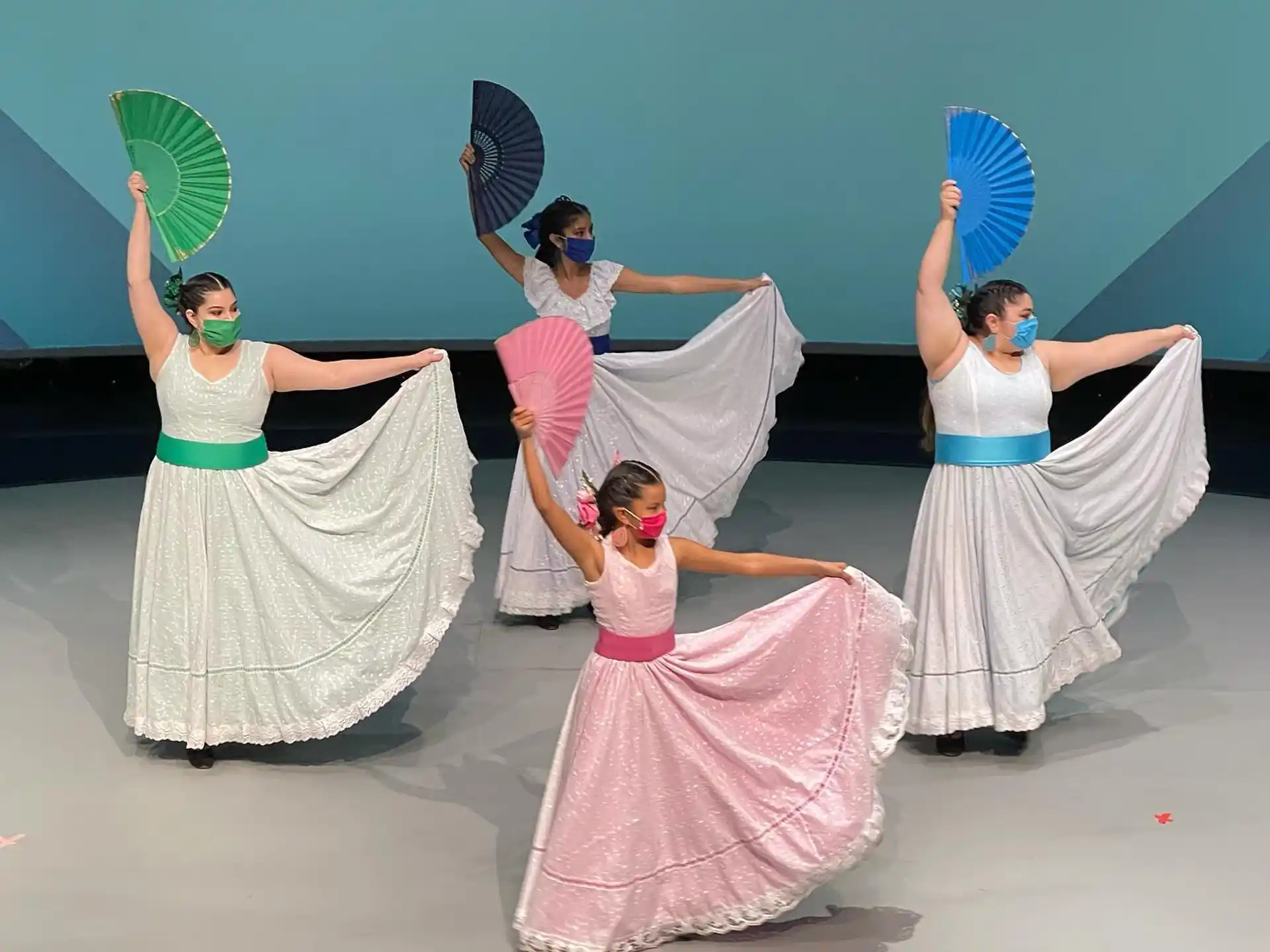 a group of women in dresses holding umbrellas