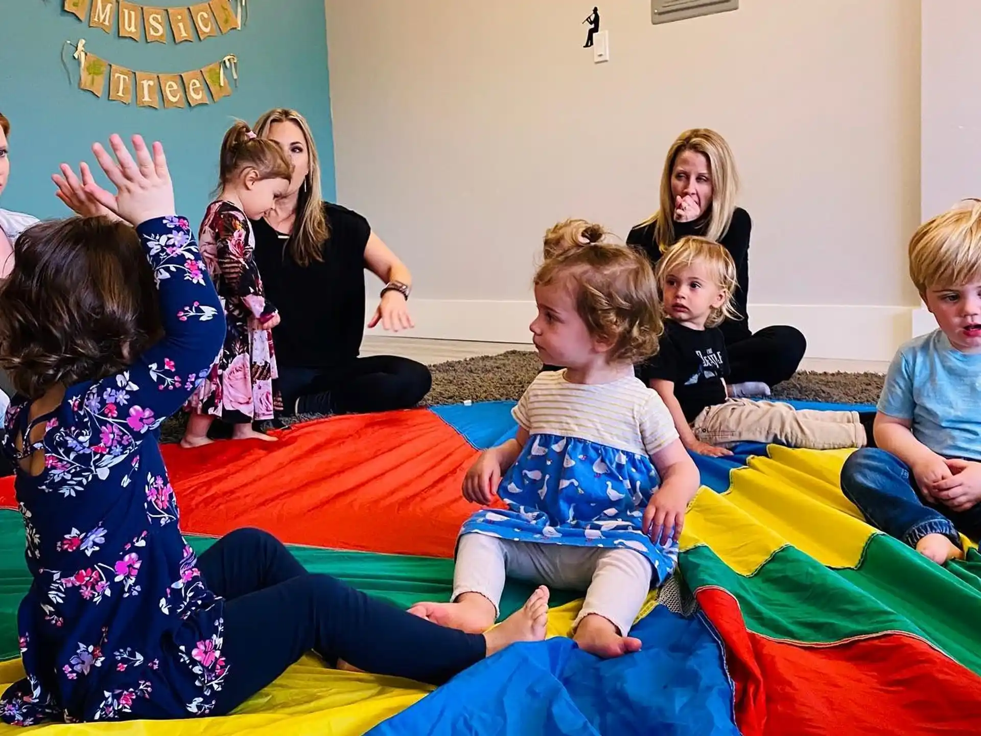 a group of children sitting on a colorful mat