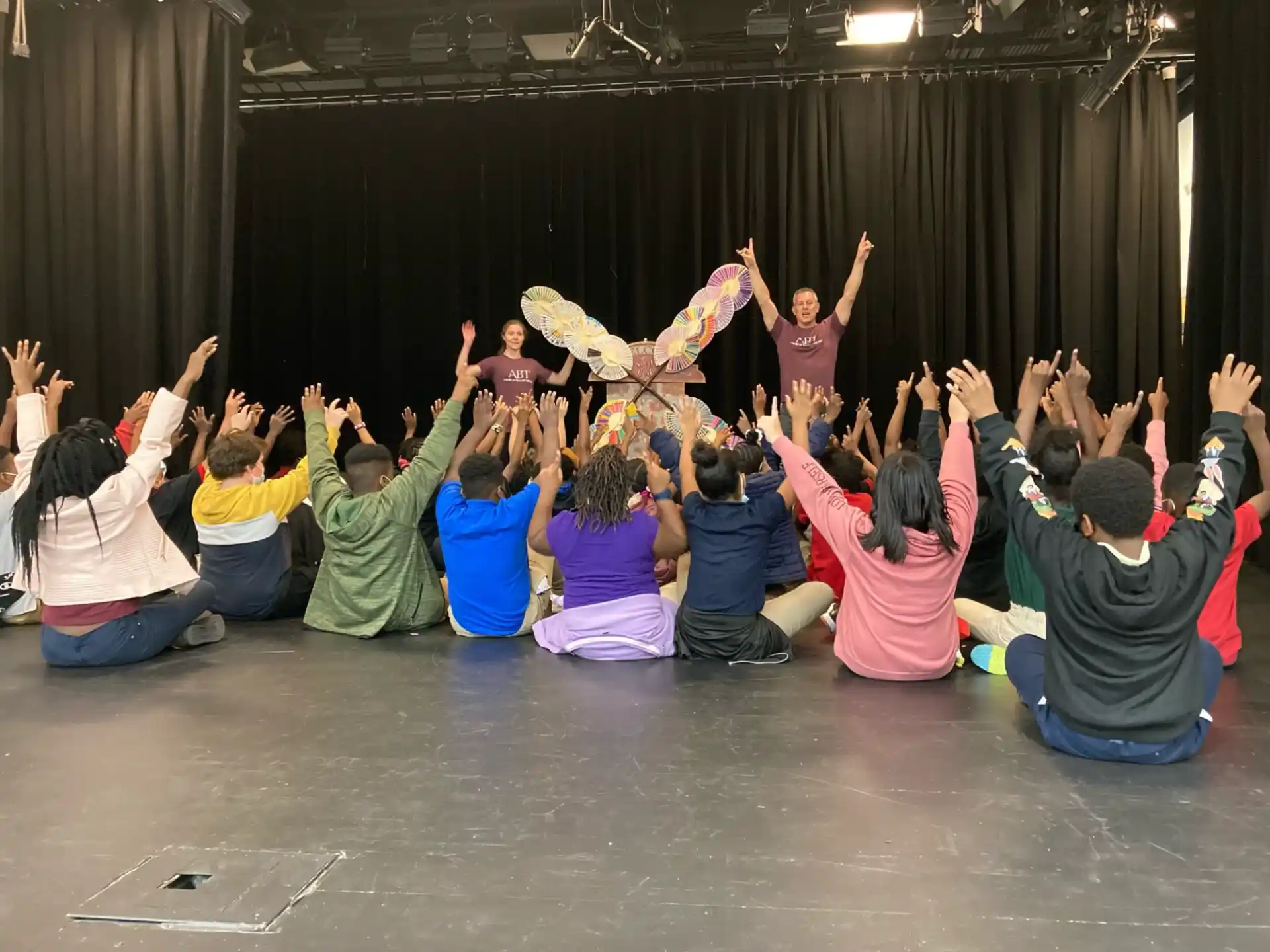 a group of people in a circle with their hands up