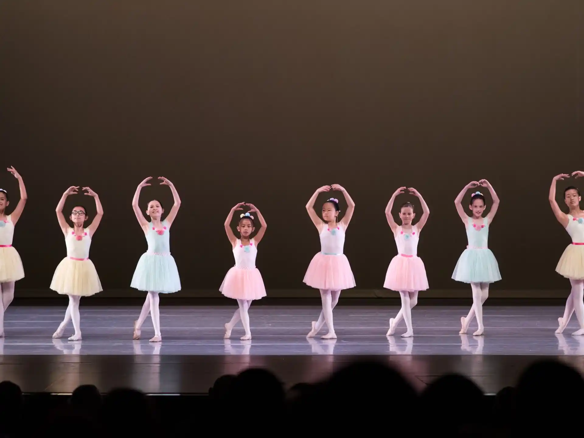 a group of girls in dresses on a stage