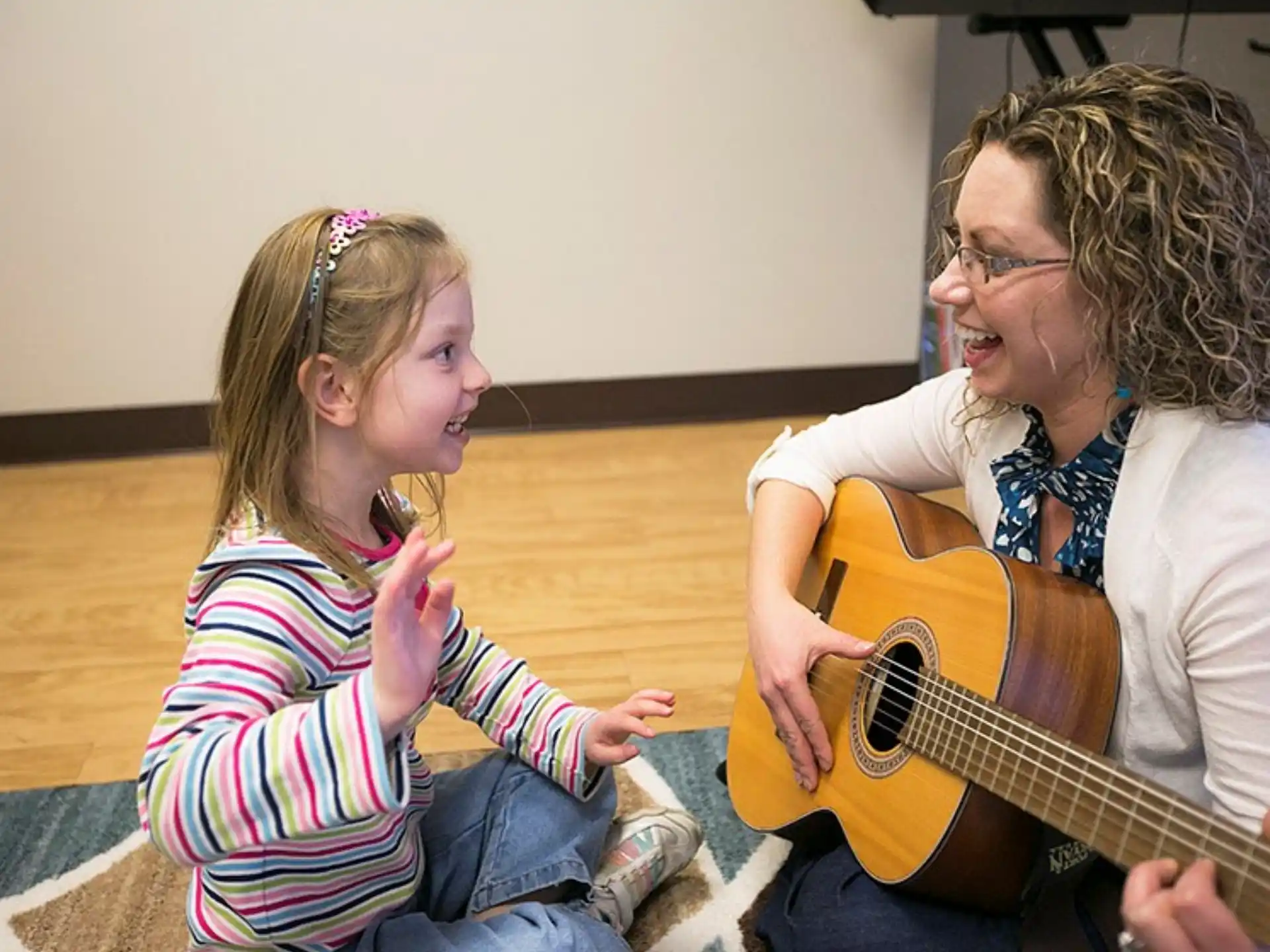 a person and a girl playing guitar