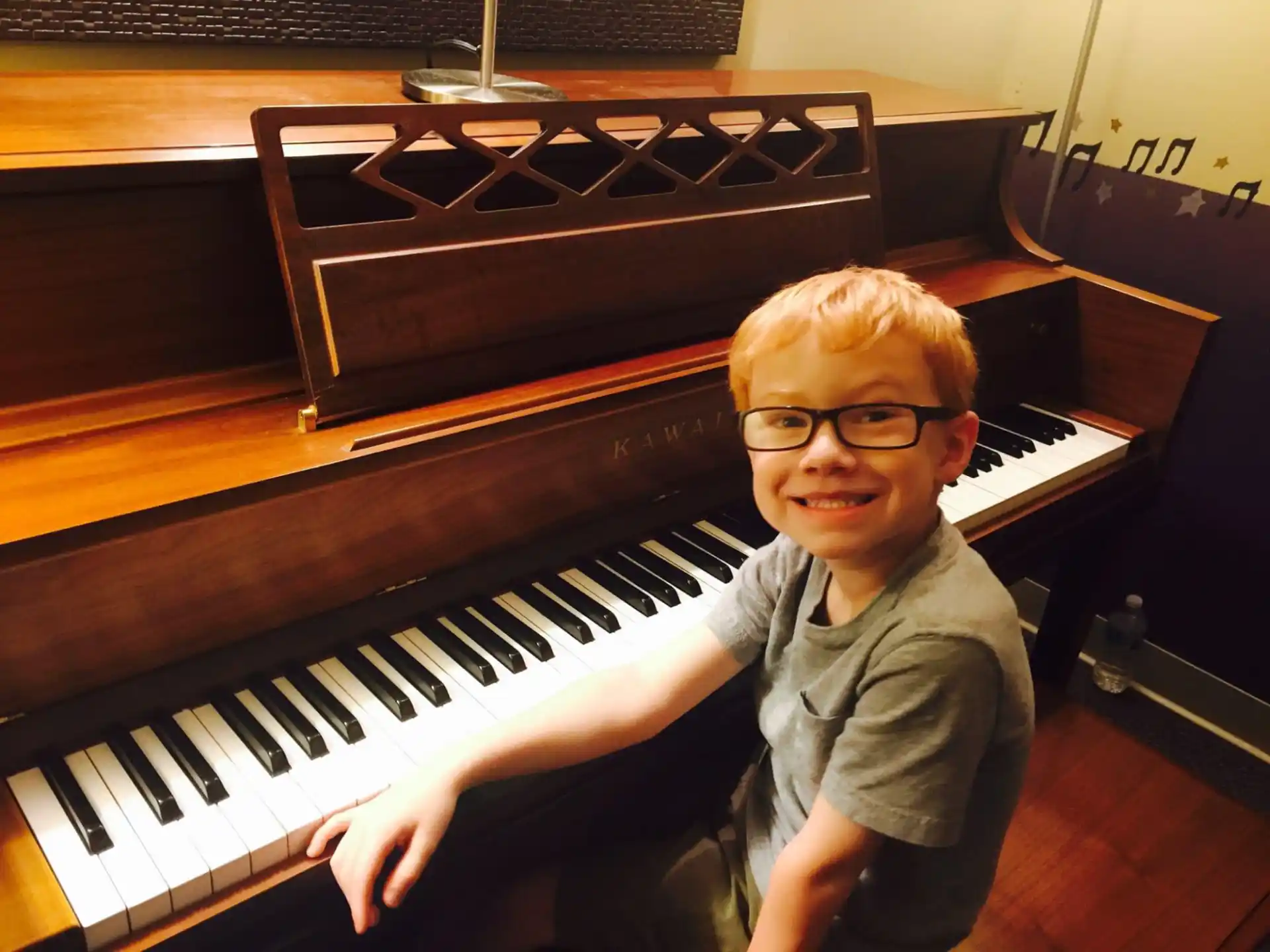 a boy sitting at a piano