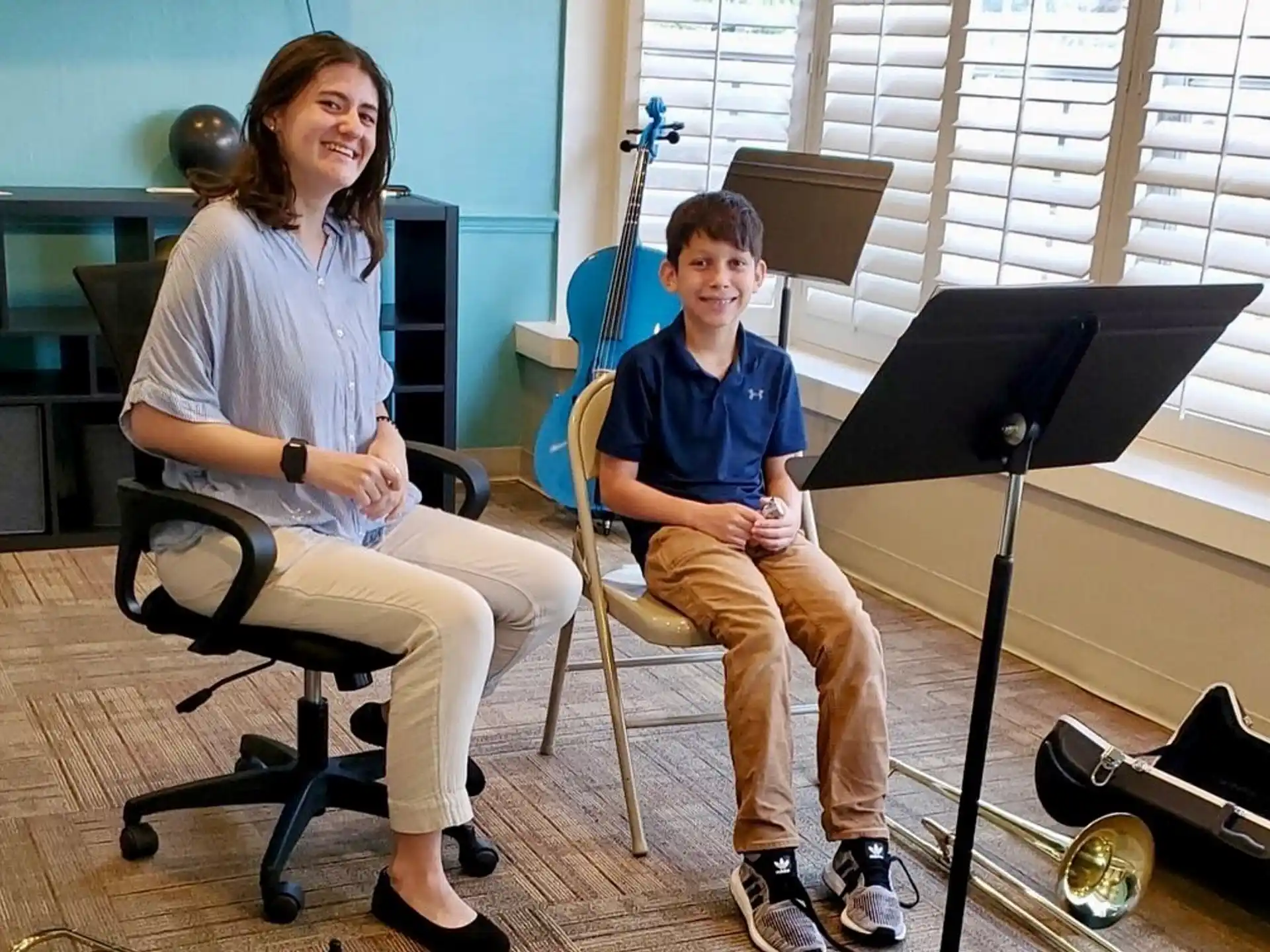 a person and a boy sitting in chairs in a room with instruments